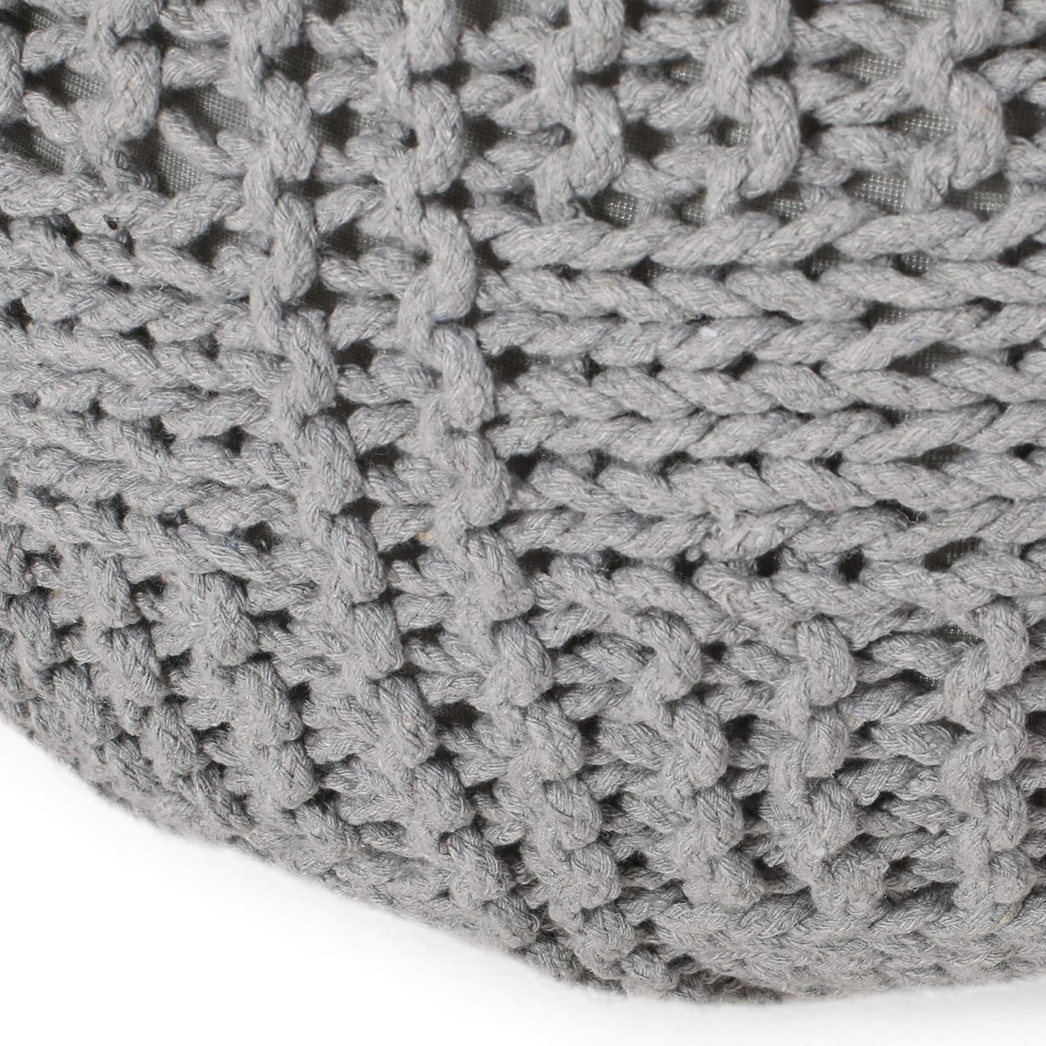 Closeup of a grey knitted pouf with a chunky cable knit texture