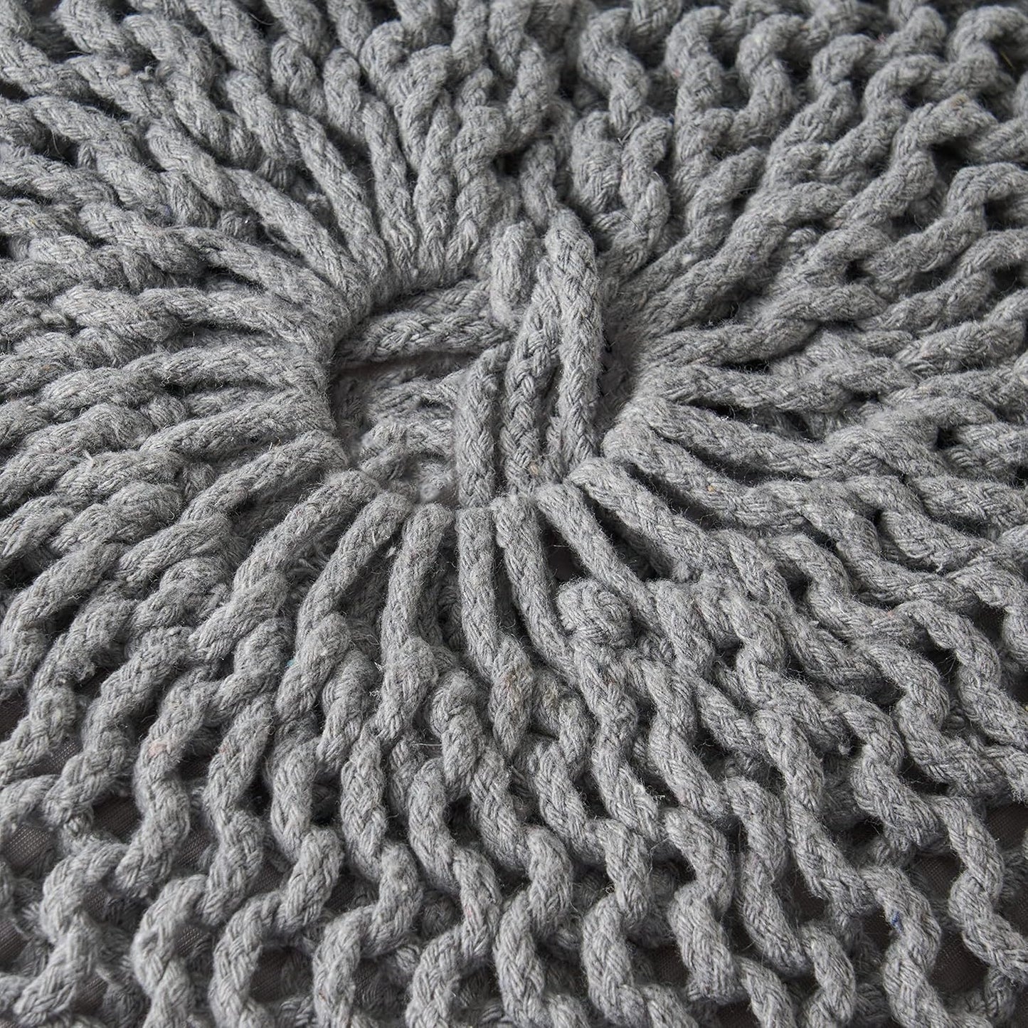 Closeup of a grey knitted pouf with a detailed woven texture