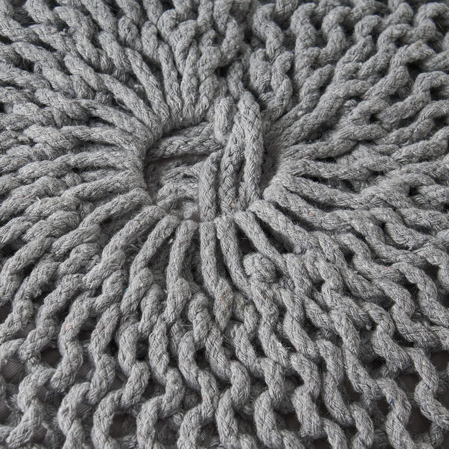 Closeup of a grey knitted pouf with a detailed woven texture