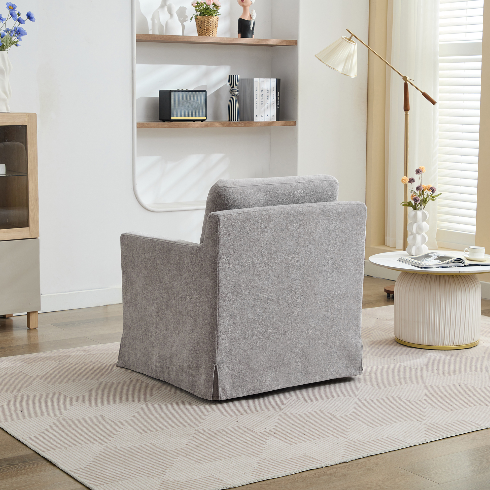Gray fabric armchair with skirted base on geometric rug