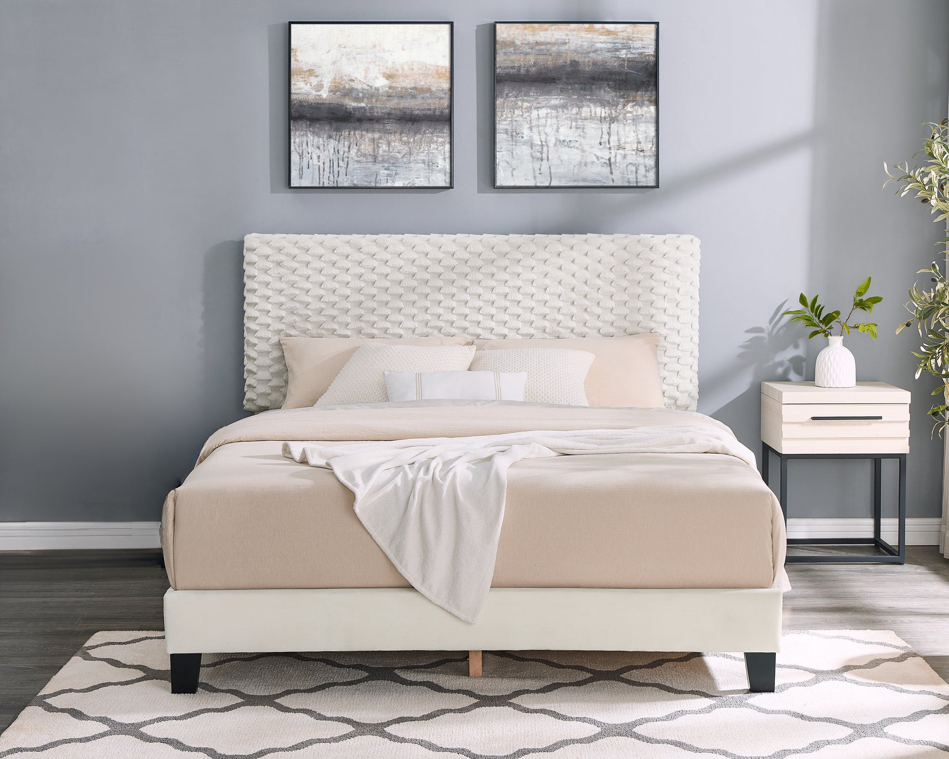 Queen size upholstered bed with textured white headboard and beige bedding