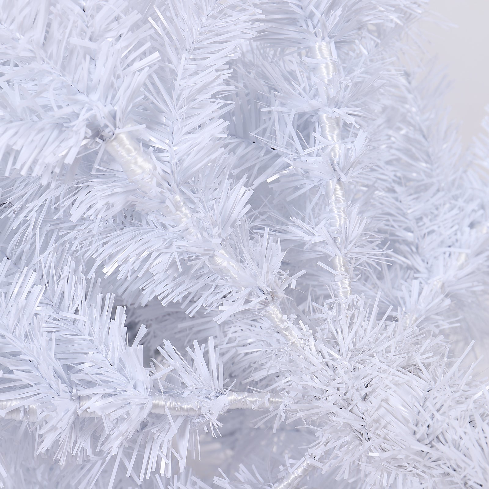 Close up of a fluffy white Christmas tree with tinsel branches for festive decor