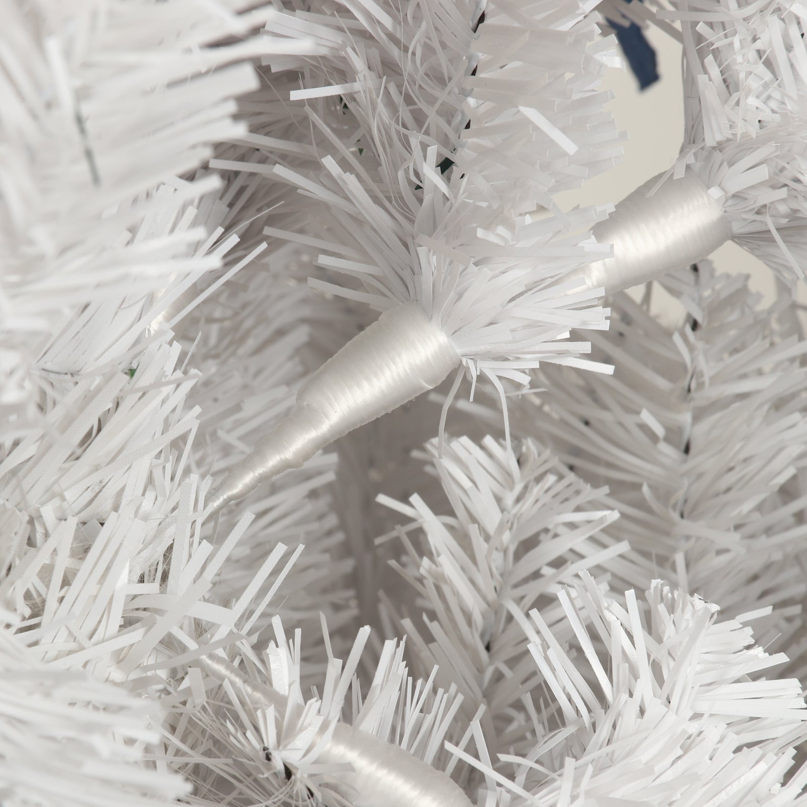 Closeup of white artificial Christmas tree needles with sparkling lights integrated
