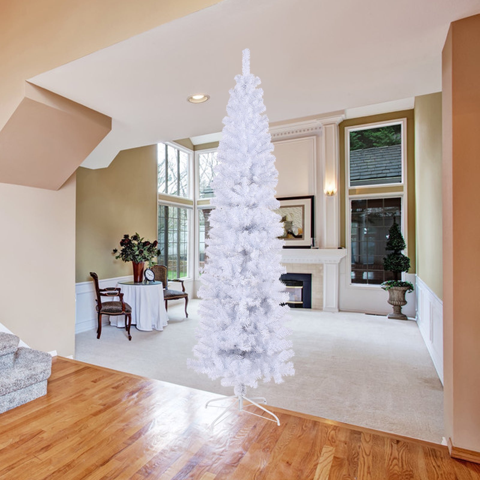 Tall slender white artificial Christmas tree with full branches set in a bright living room