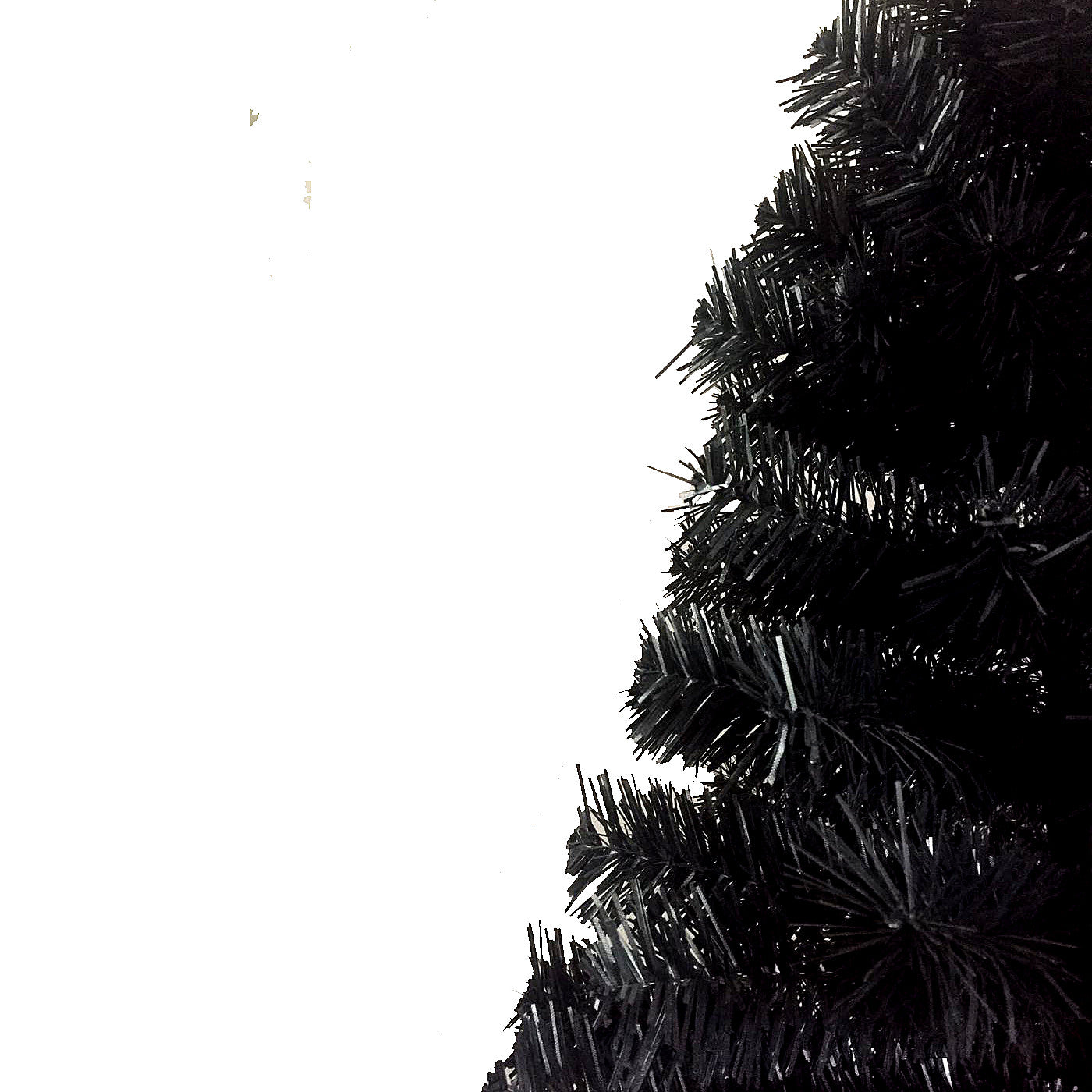 Closeup of dense black artificial Christmas tree branches against a white background