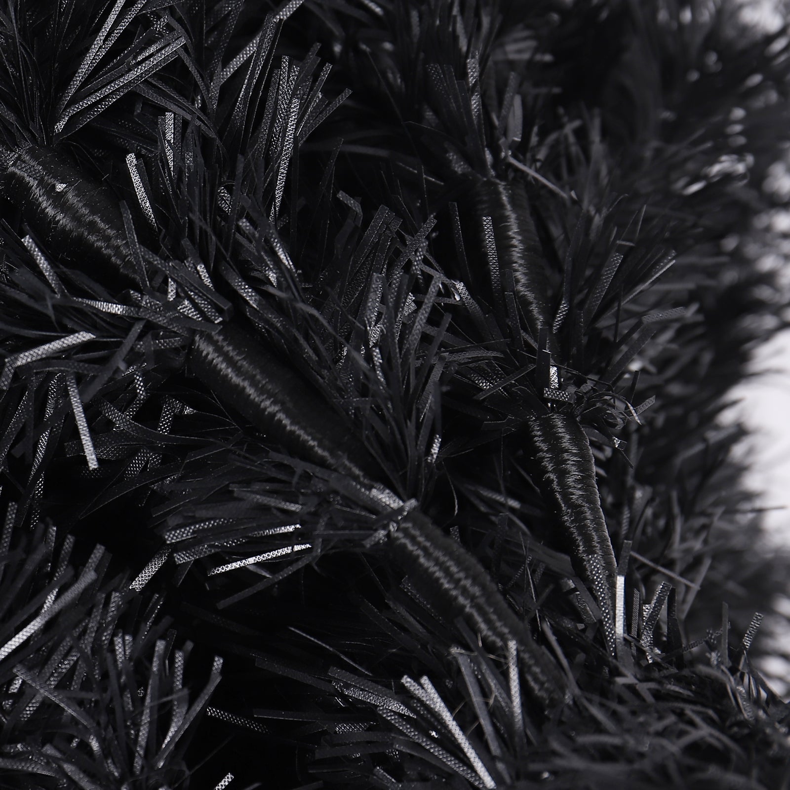Closeup of a black artificial Christmas garland with tinsel branches