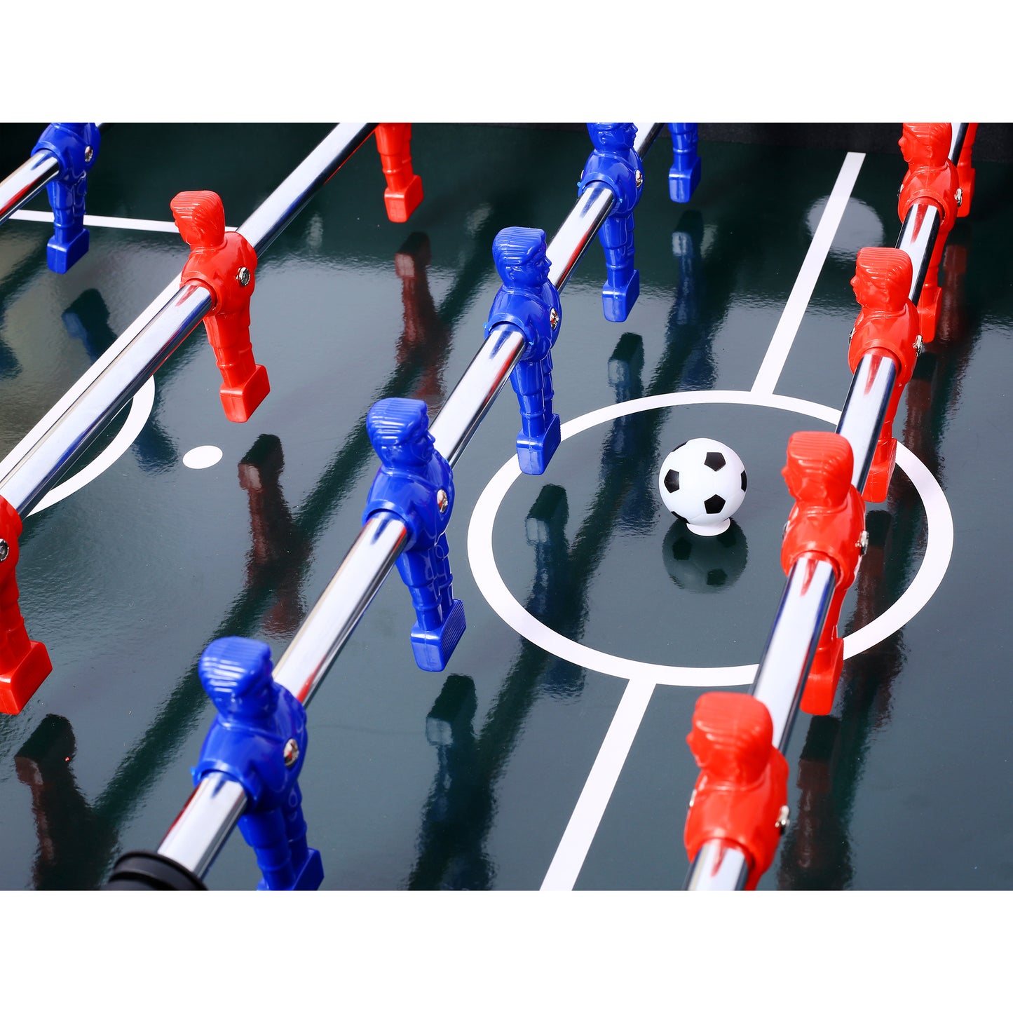 Closeup of red and blue foosball players on a green table with a miniature soccer ball