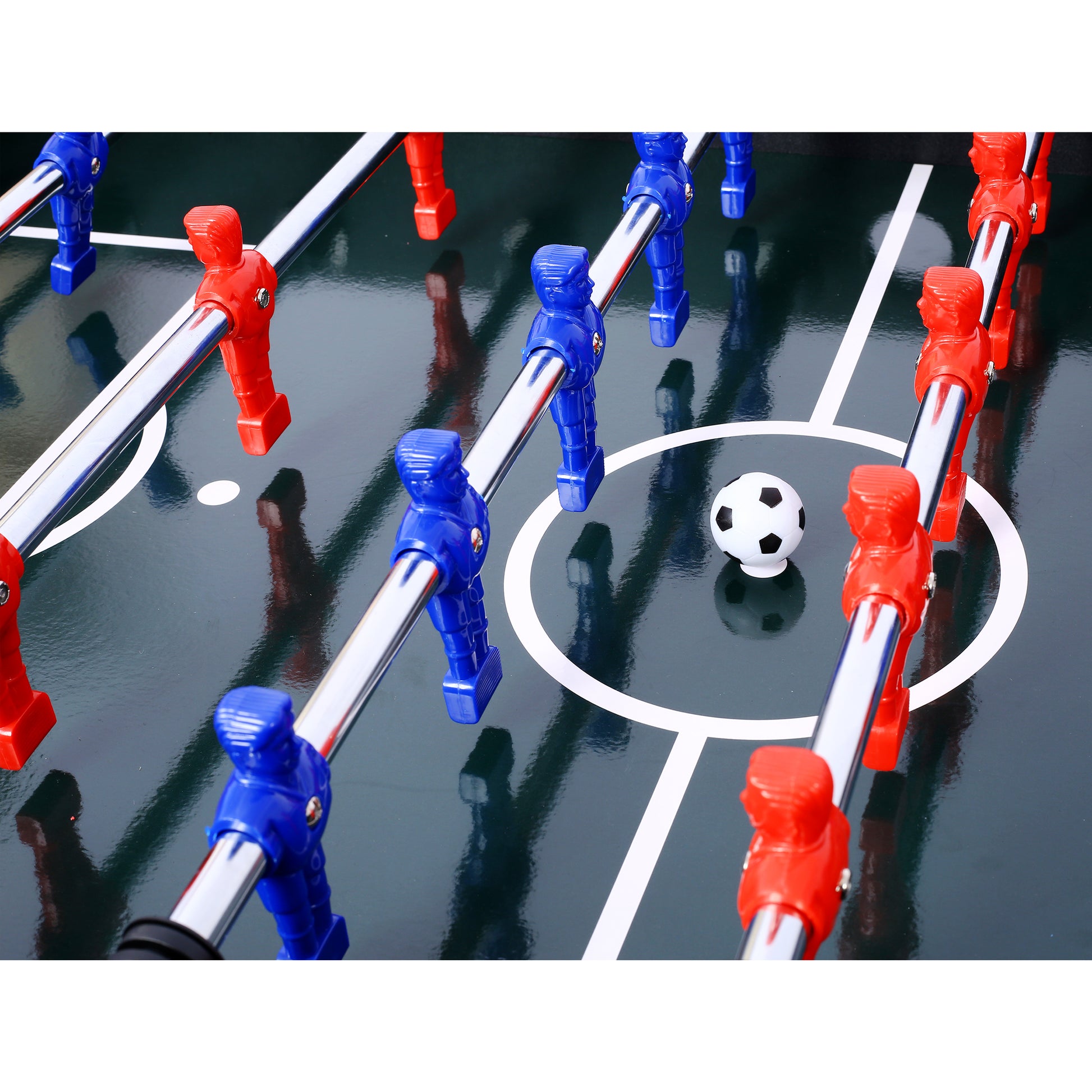 Closeup of red and blue foosball players on a green table with a miniature soccer ball