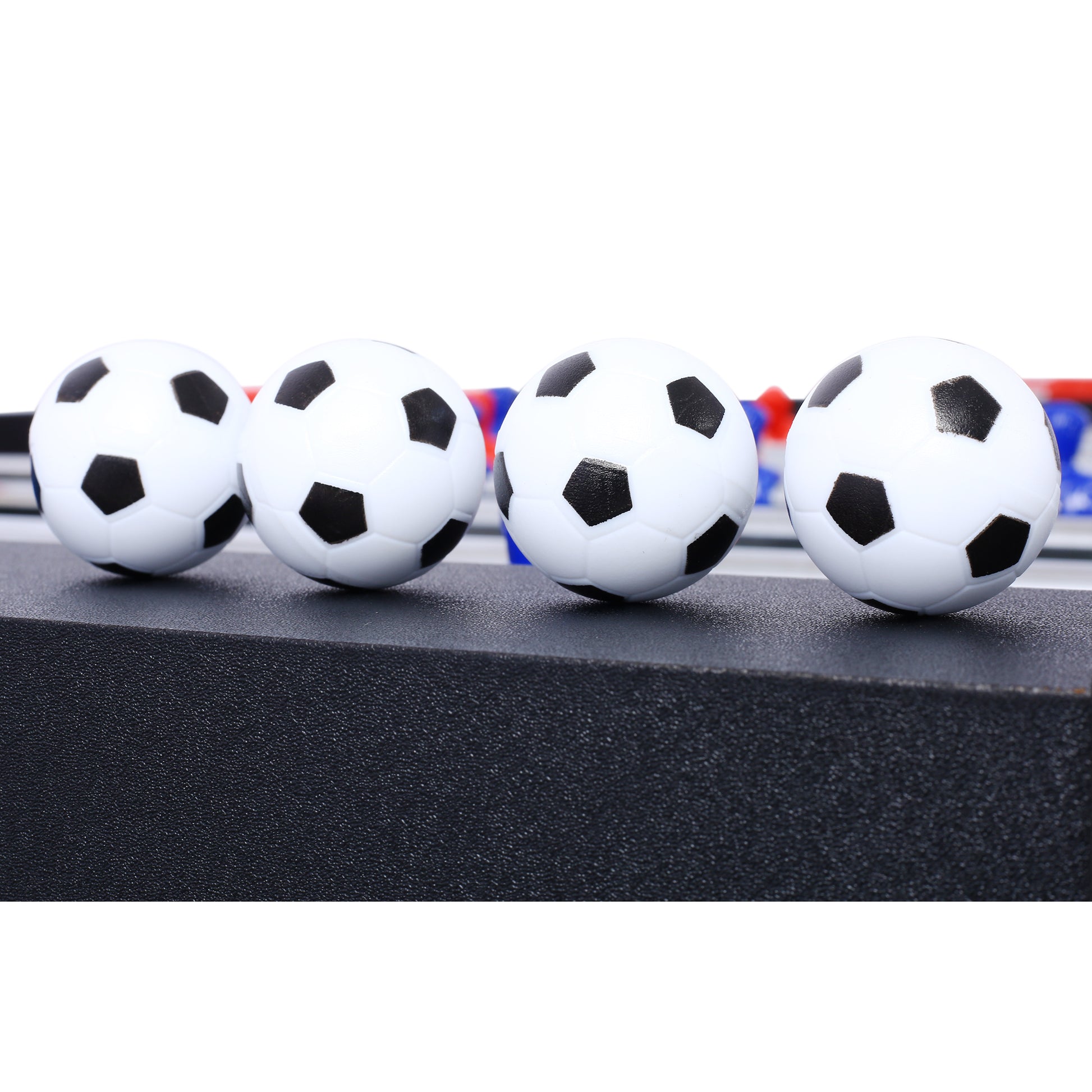 Four miniature white soccer balls with black pentagons perfect for foosball tables