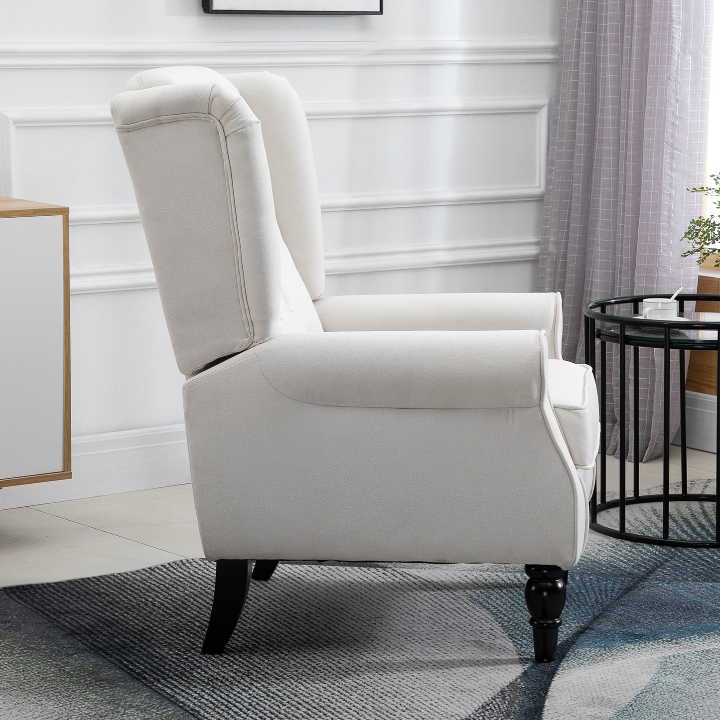 Cream linen wingback chair with black wooden legs and upholstered arms