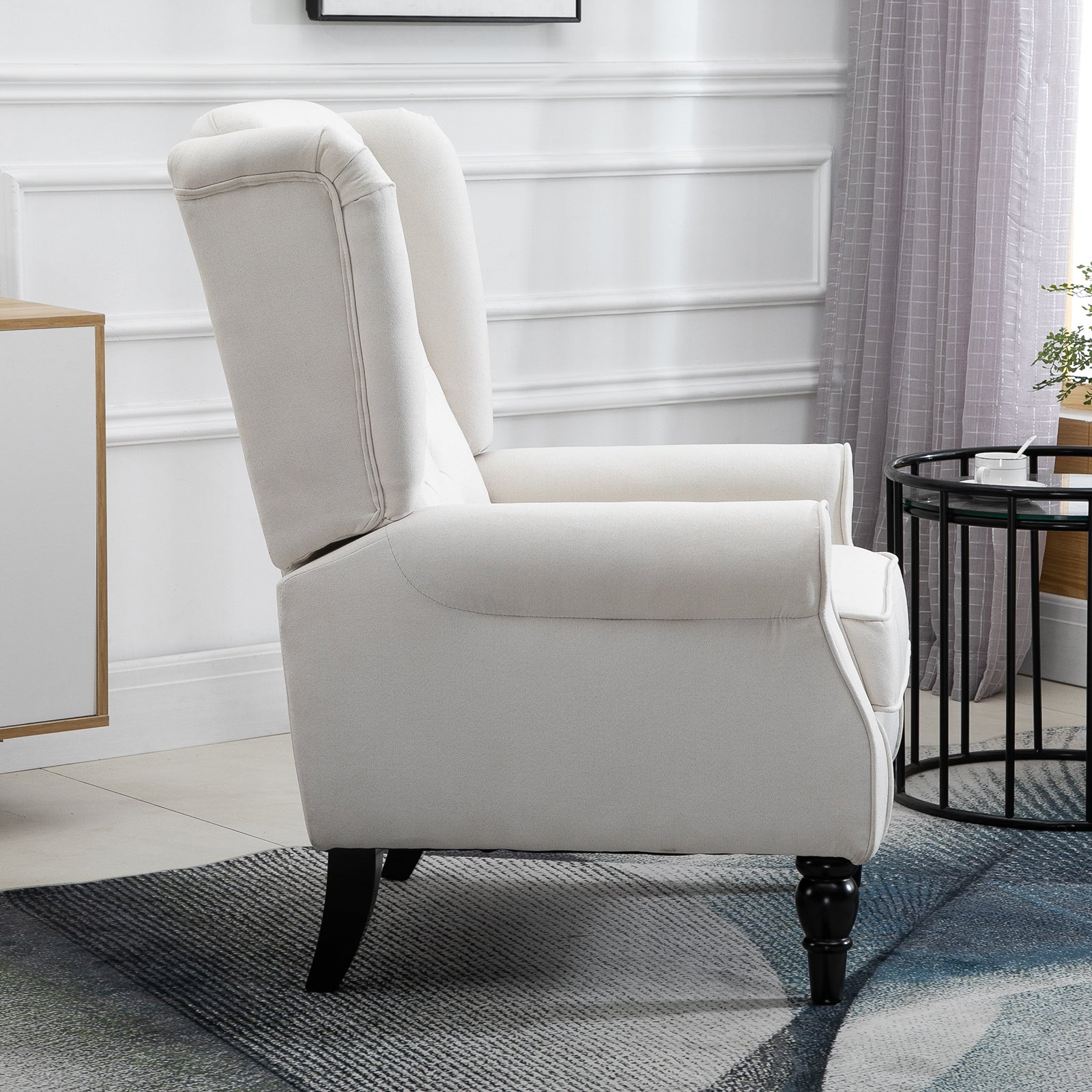 Cream linen wingback chair with black wooden legs and upholstered arms