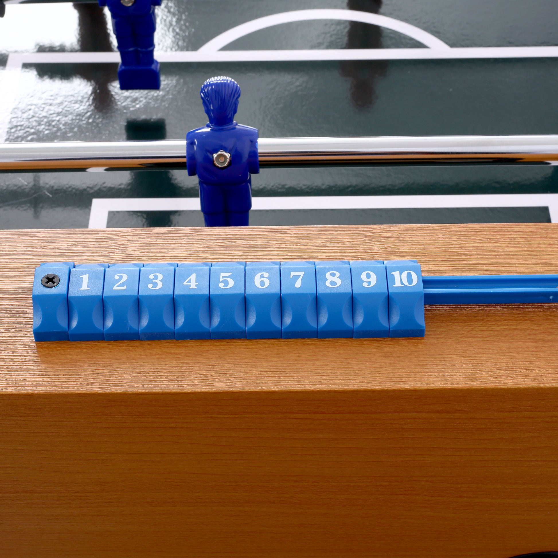 Blue foosball players on a green pitch ready for a game