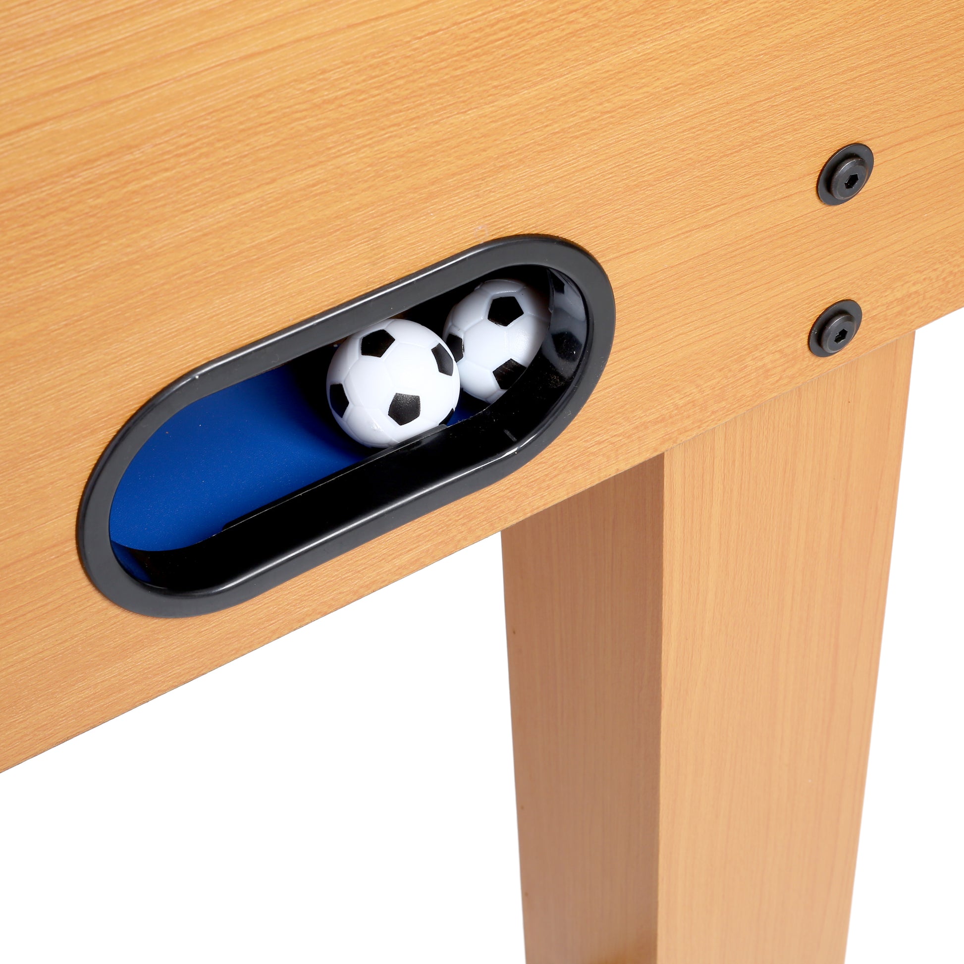 Lightwood foosball table corner with black screws and two white soccer balls in side slot