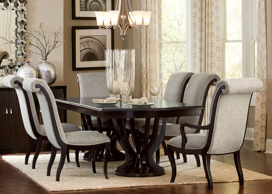 Dark wood dining table with upholstered gray chairs and silver nailhead trim