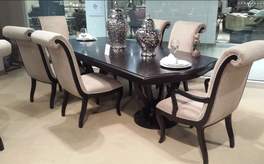 Elegant dark wood dining table with upholstered chairs featuring silver decorative urns