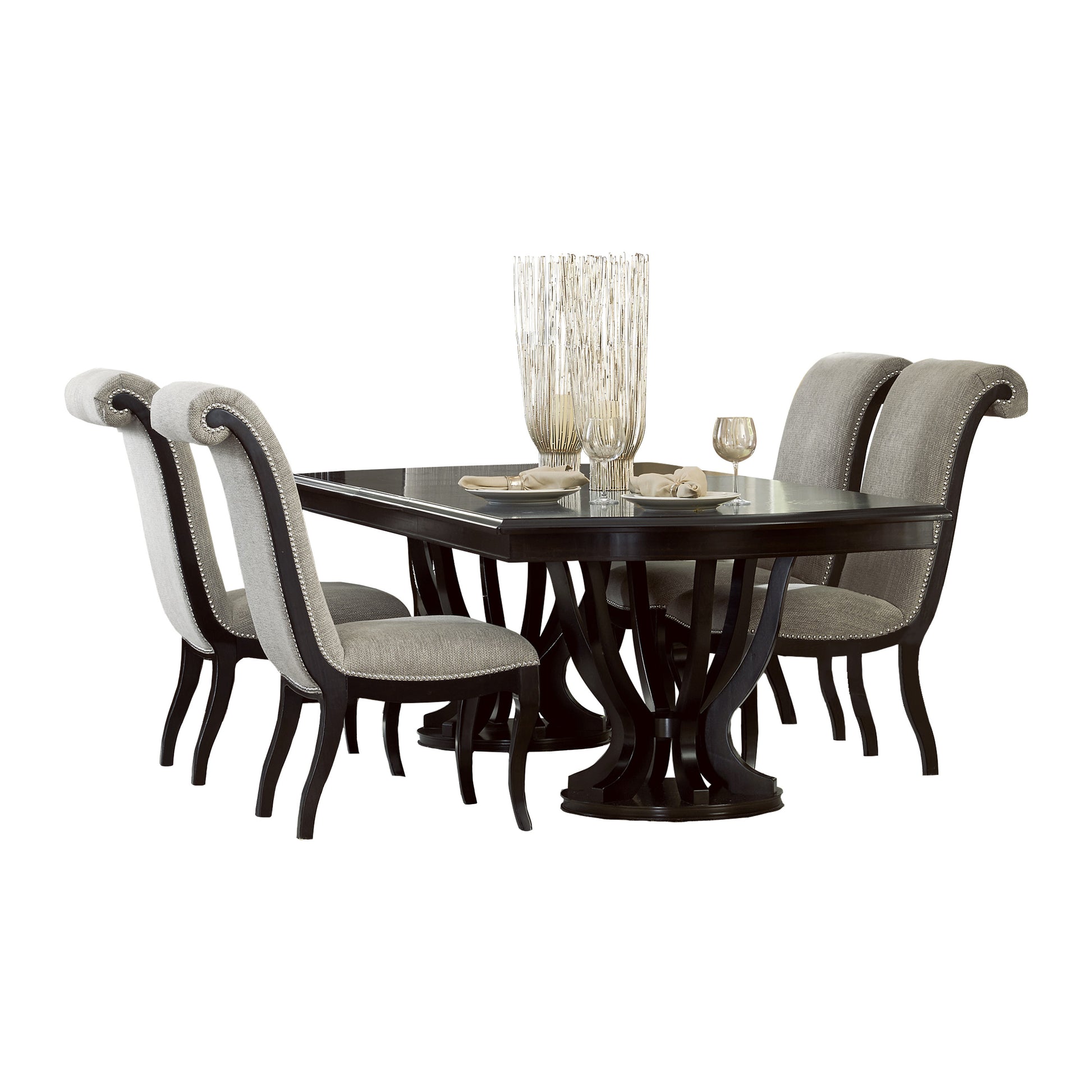 Dark wood dining table with ornate base and four grey upholstered chairs with nailhead trim