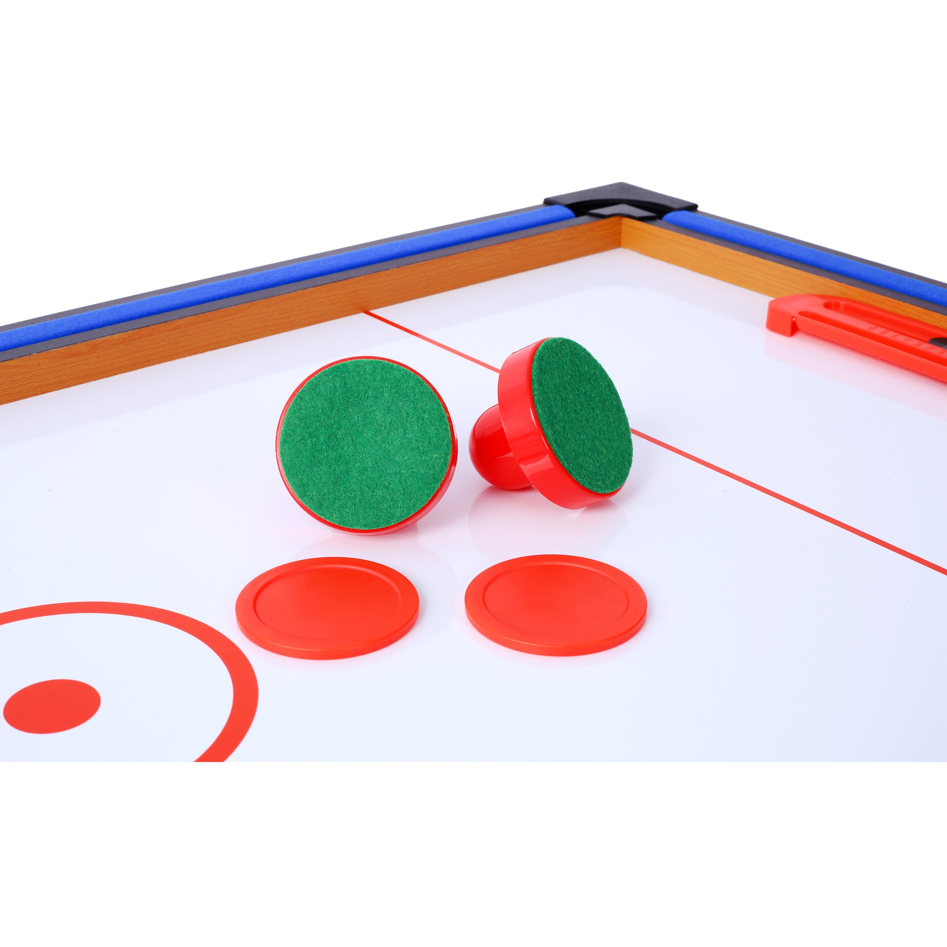 Two red air hockey paddles with green felt bottoms and two red pucks on a white air hockey table