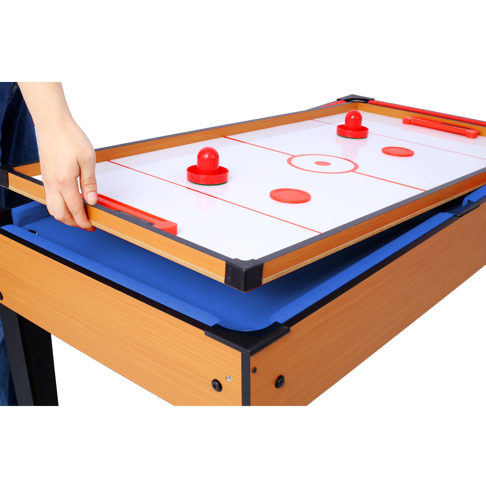 Closeup of a multigame table showing the air hockey board with red pucks and mallets
