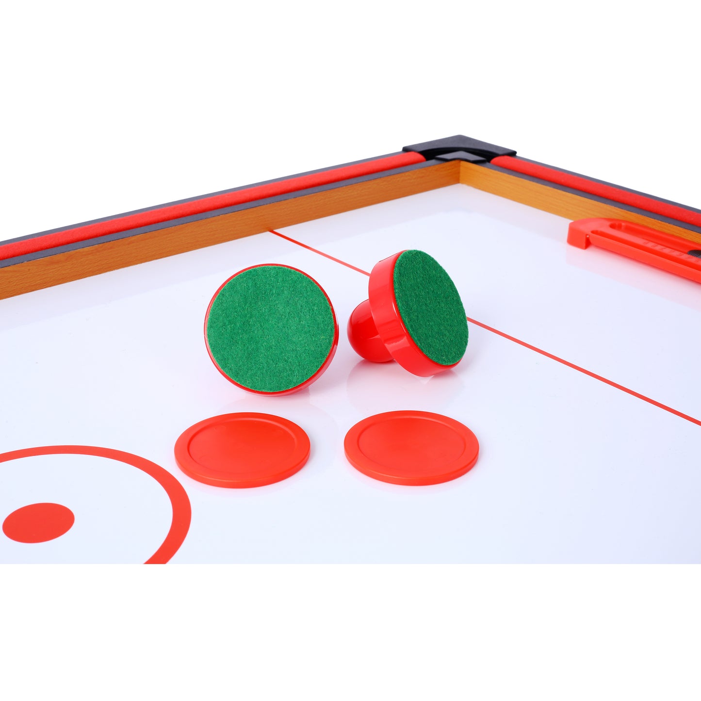 Red and green air hockey strikers with orange pucks on table