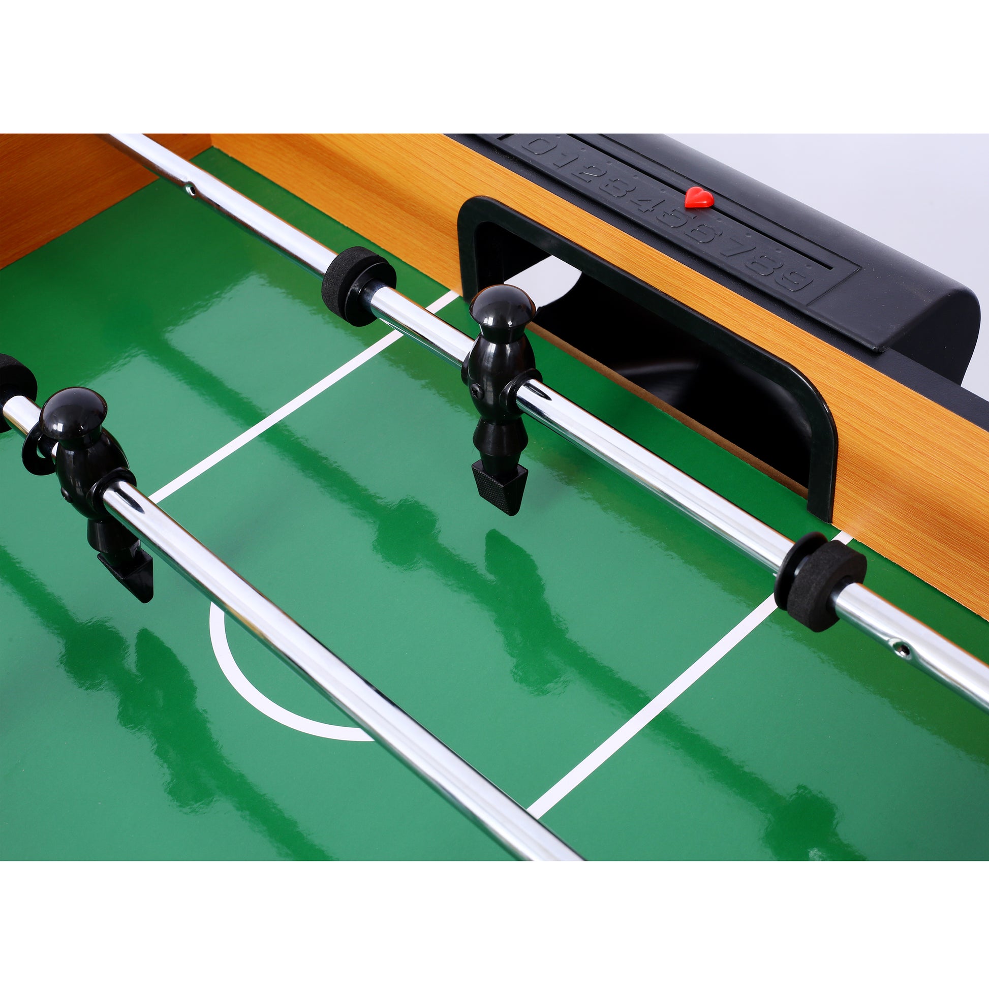 Closeup of a foosball table with green playing field and black player figures