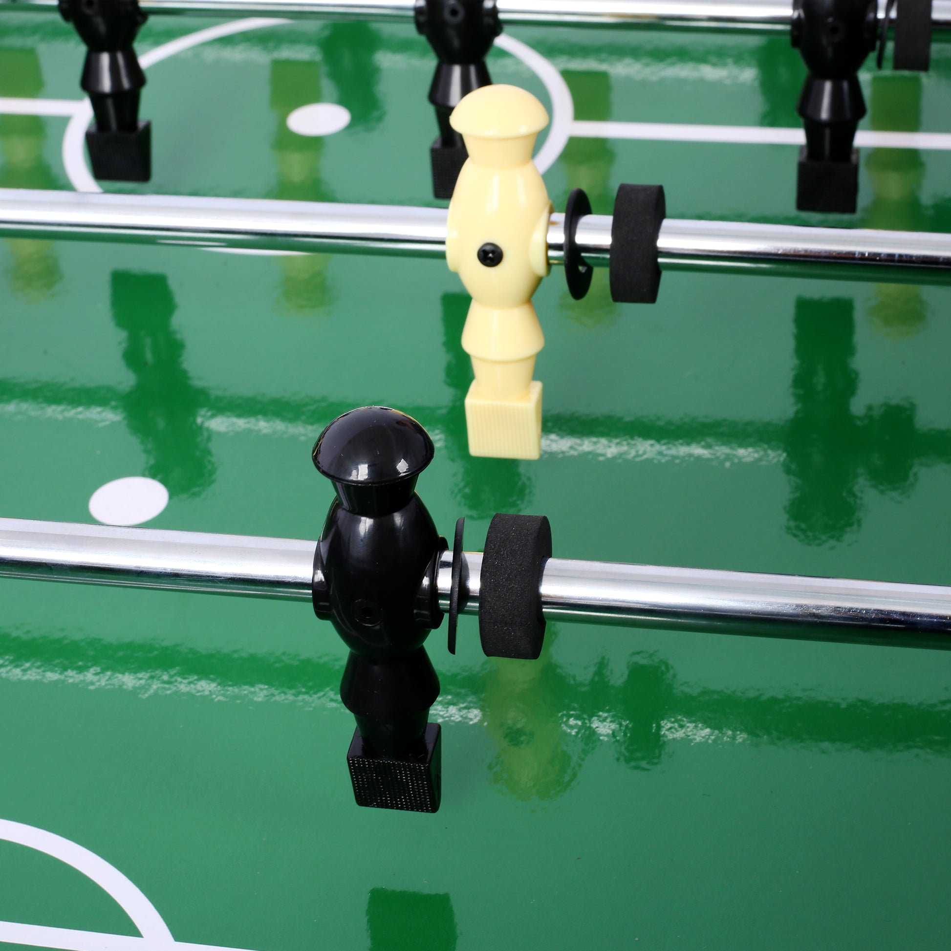 Black foosball player figure on green field ready for game action