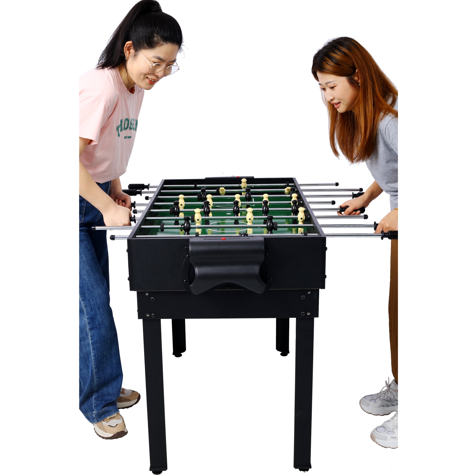 Black foosball table with green felt surface and yellow and black players two women playing