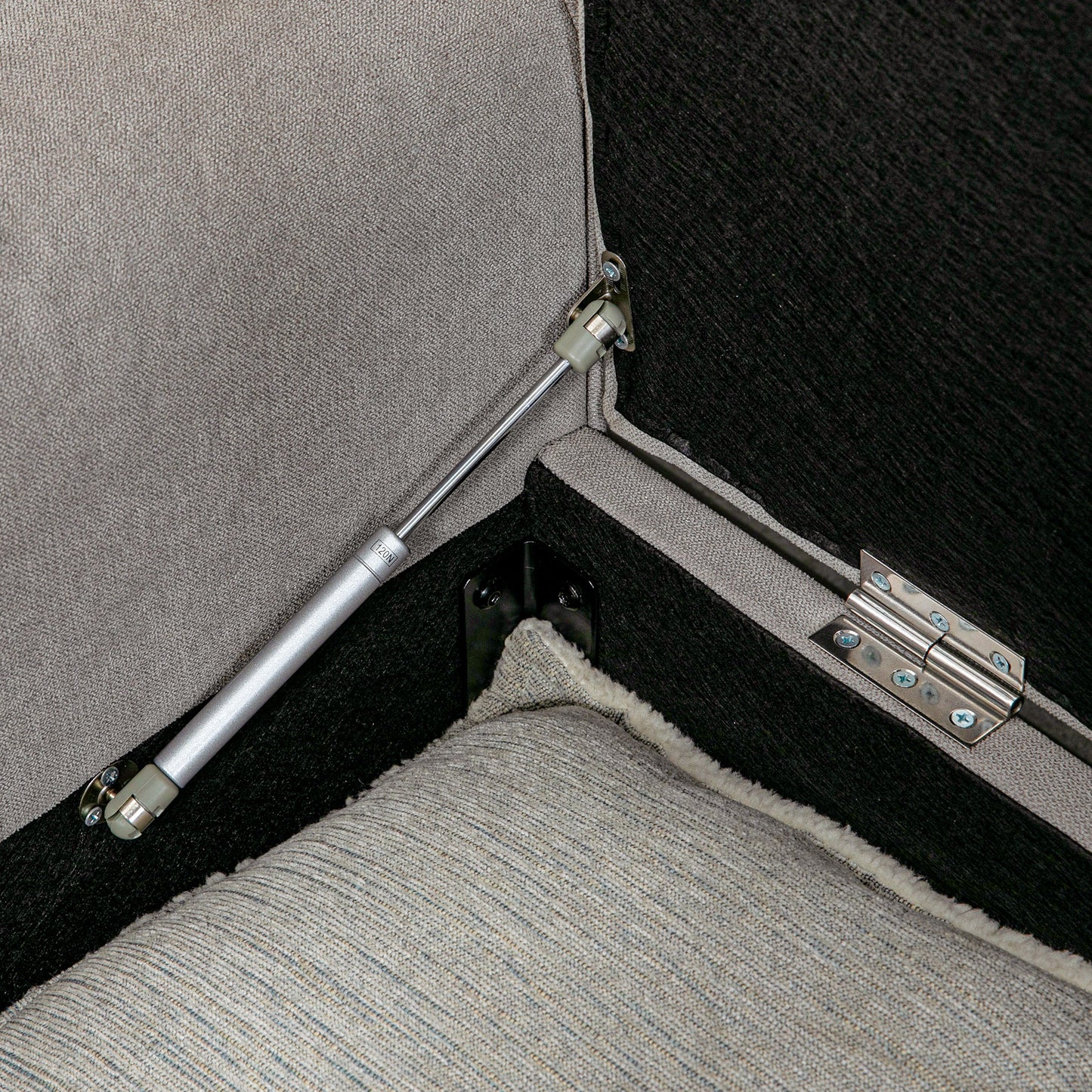 Closeup of ottoman hinge mechanism with gas lift strut