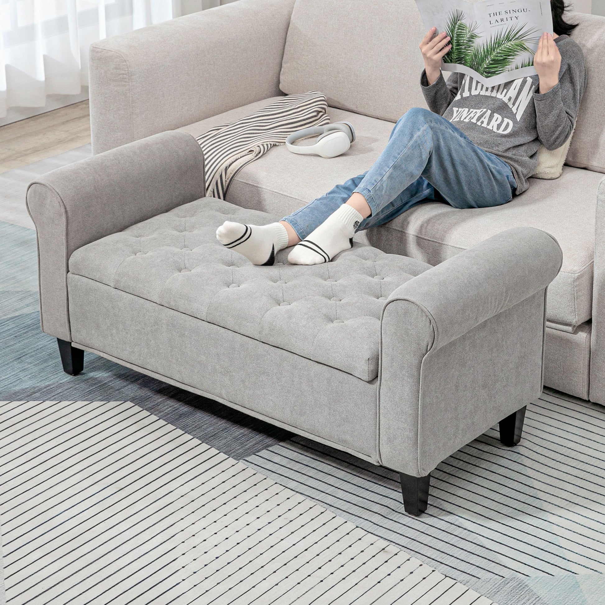 Tufted grey fabric storage ottoman with scrolled arms