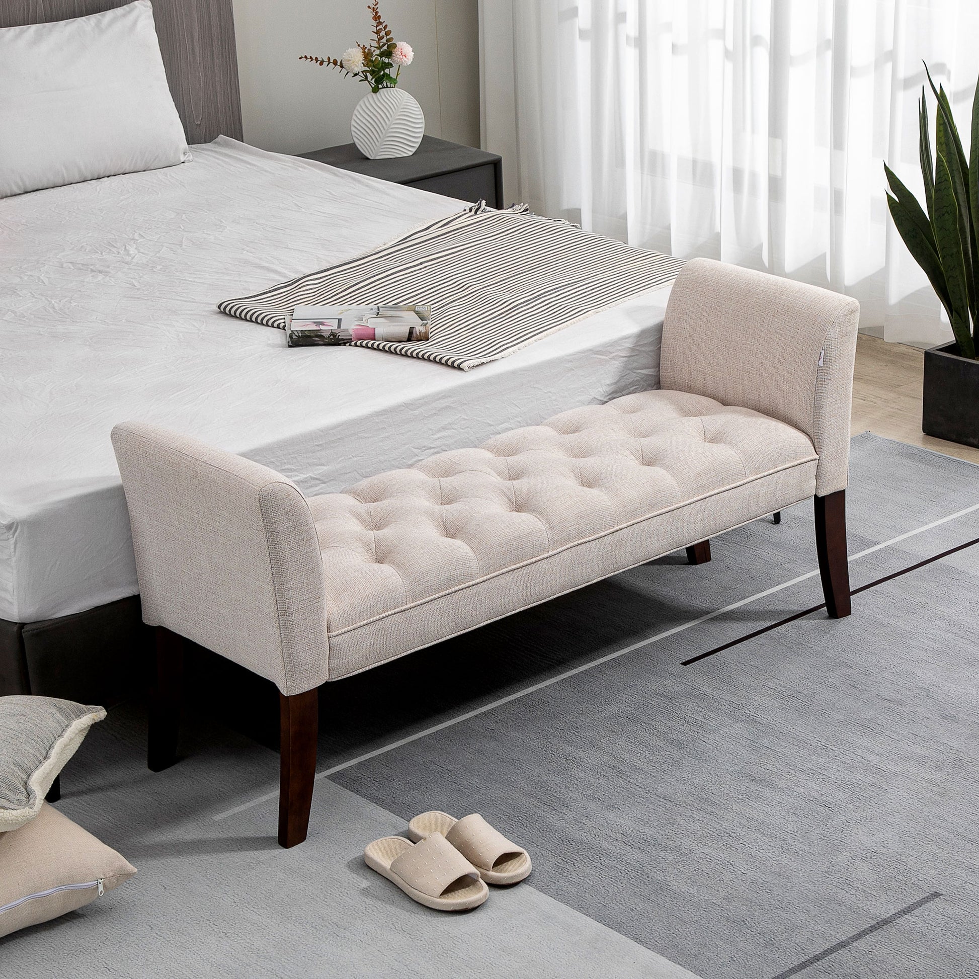 Beige linen upholstered storage bench with button tufting and dark wood legs