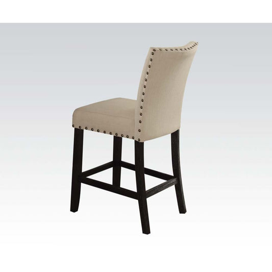 Beige upholstered counter stool with dark wood legs and nailhead trim