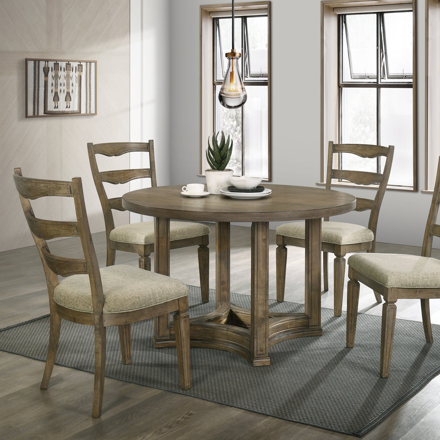 Round oak dining table with four upholstered chairs and a modern pendant light
