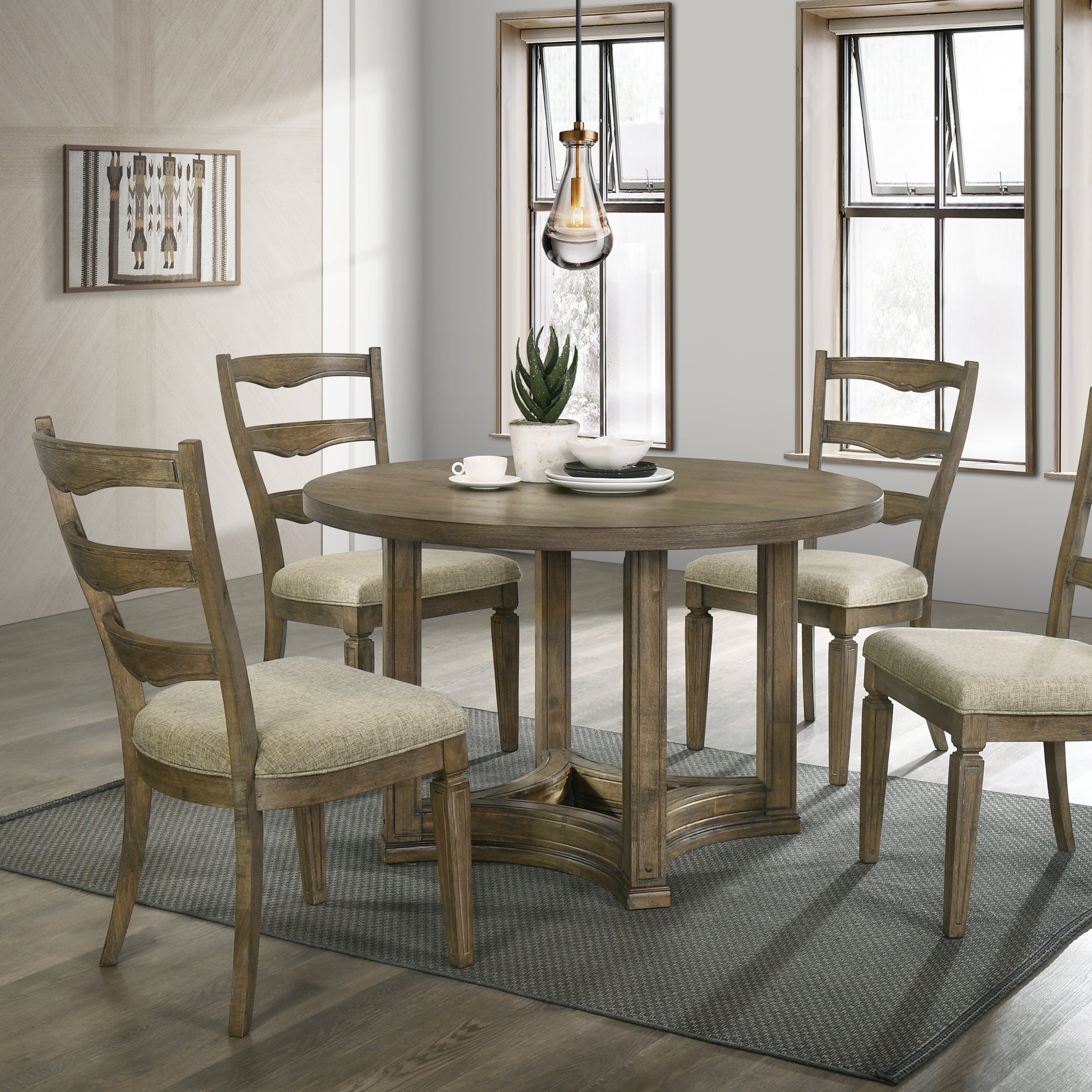 Round oak dining table with four upholstered chairs and a modern pendant light