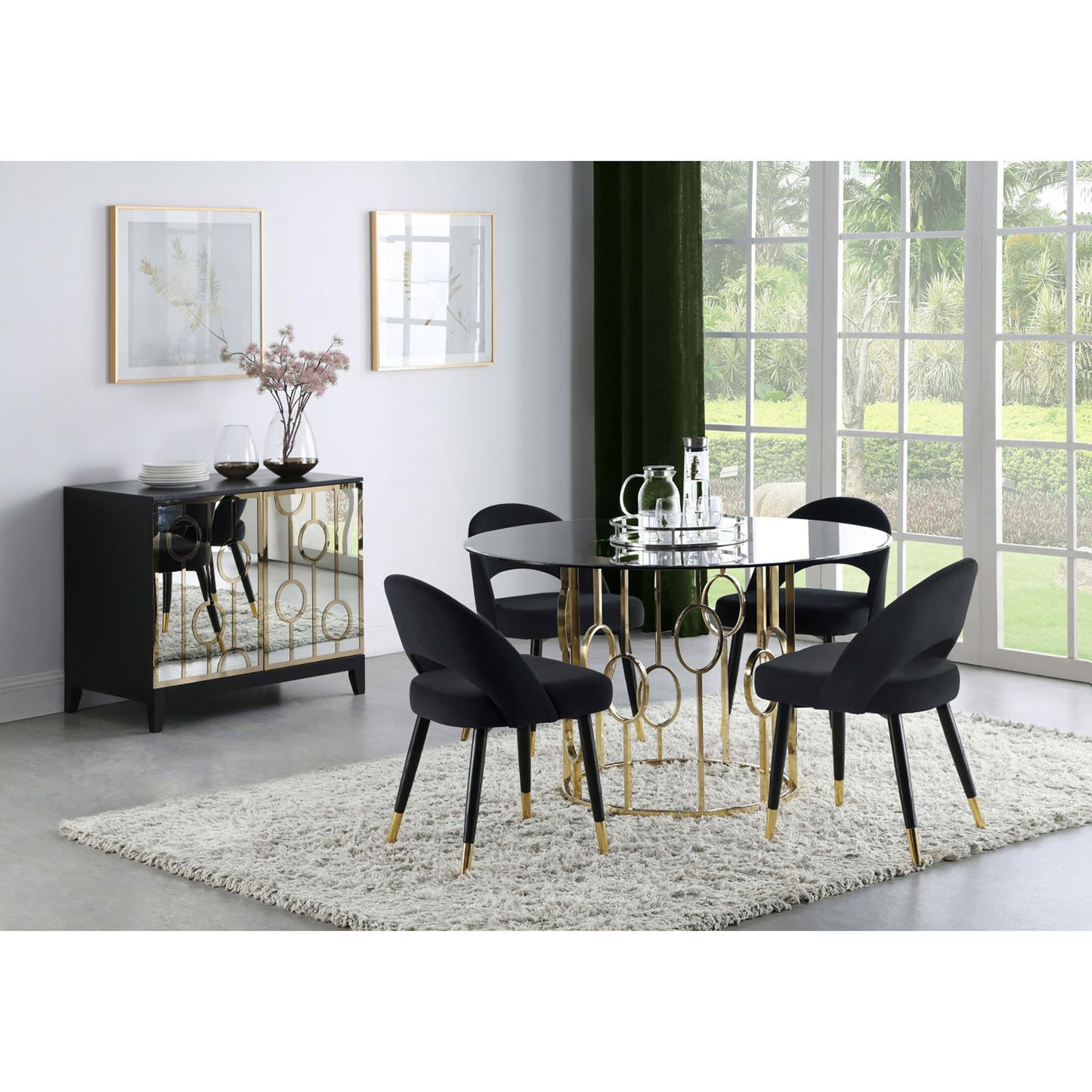 Black velvet dining chairs with gold accents around a glasstop table with gold base