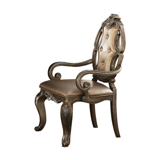 Antique dining chair with buttontufted champagne upholstery and ornate silver wood trim