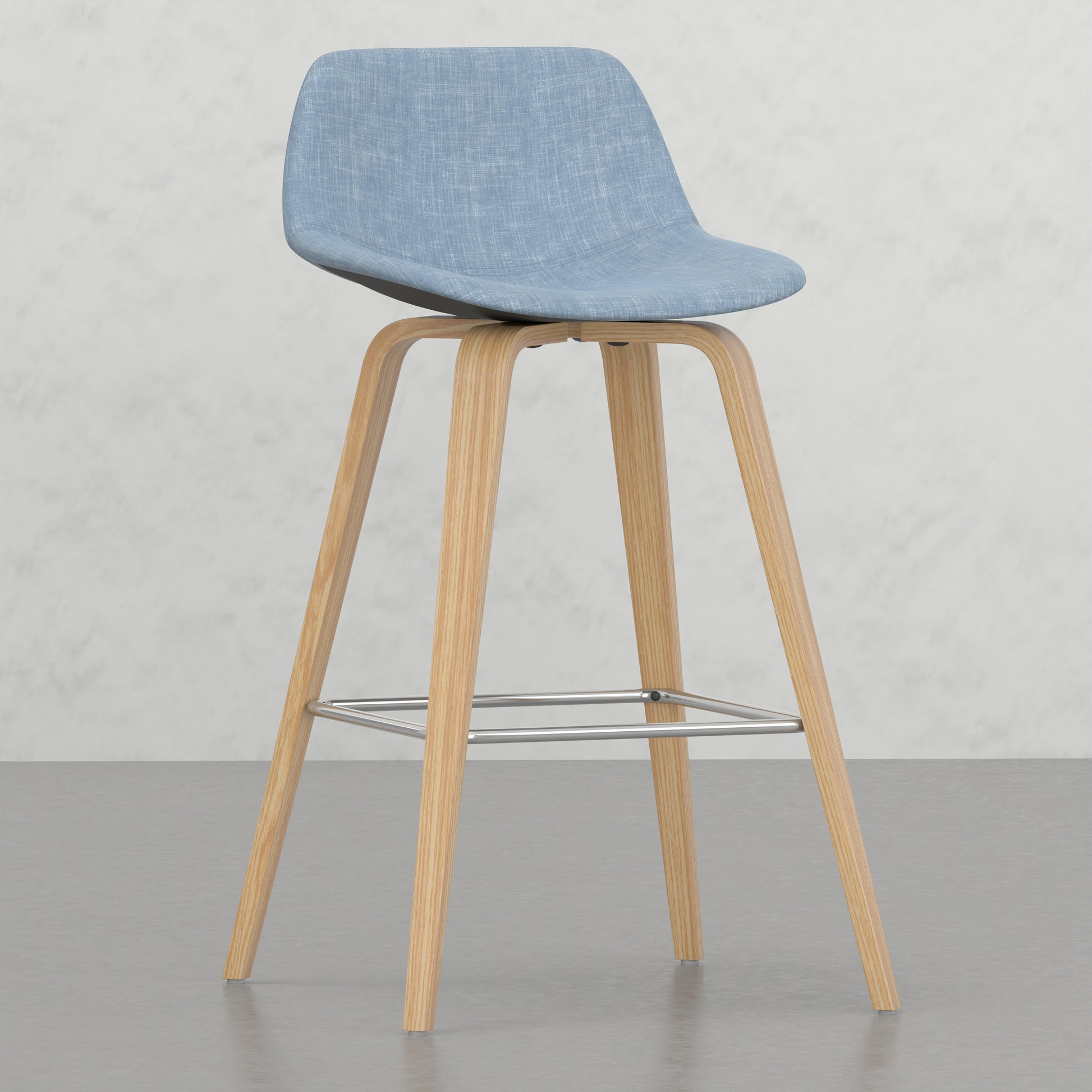 Light blue upholstered bar stool with natural wood legs and chrome footrest