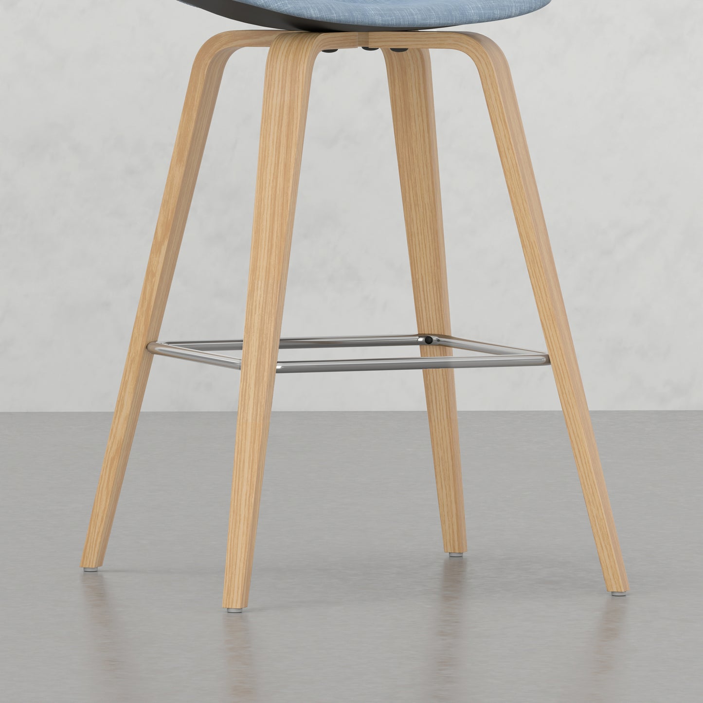 Light blue fabric bar stool with natural wood legs and chrome footrest