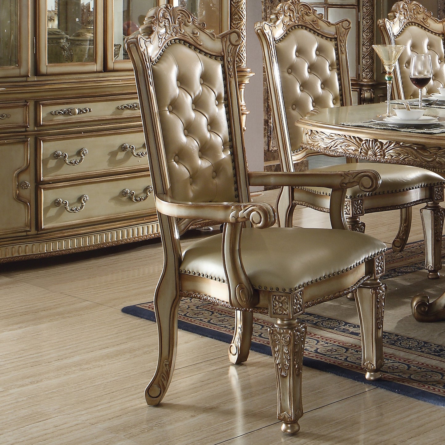 Ornate dining chair with tufted champagne leather upholstery and carved wooden frame