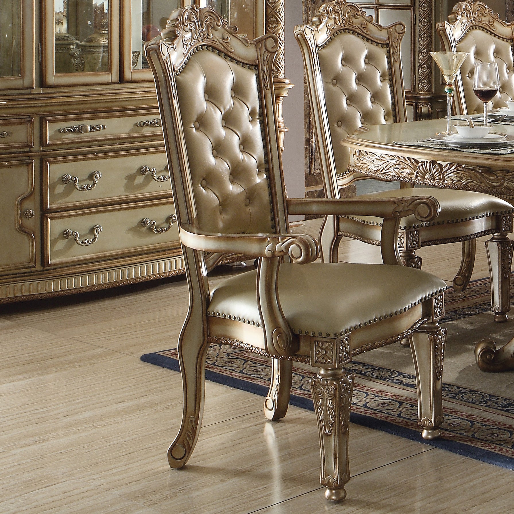 Ornate dining chair with tufted champagne leather upholstery and carved wooden frame