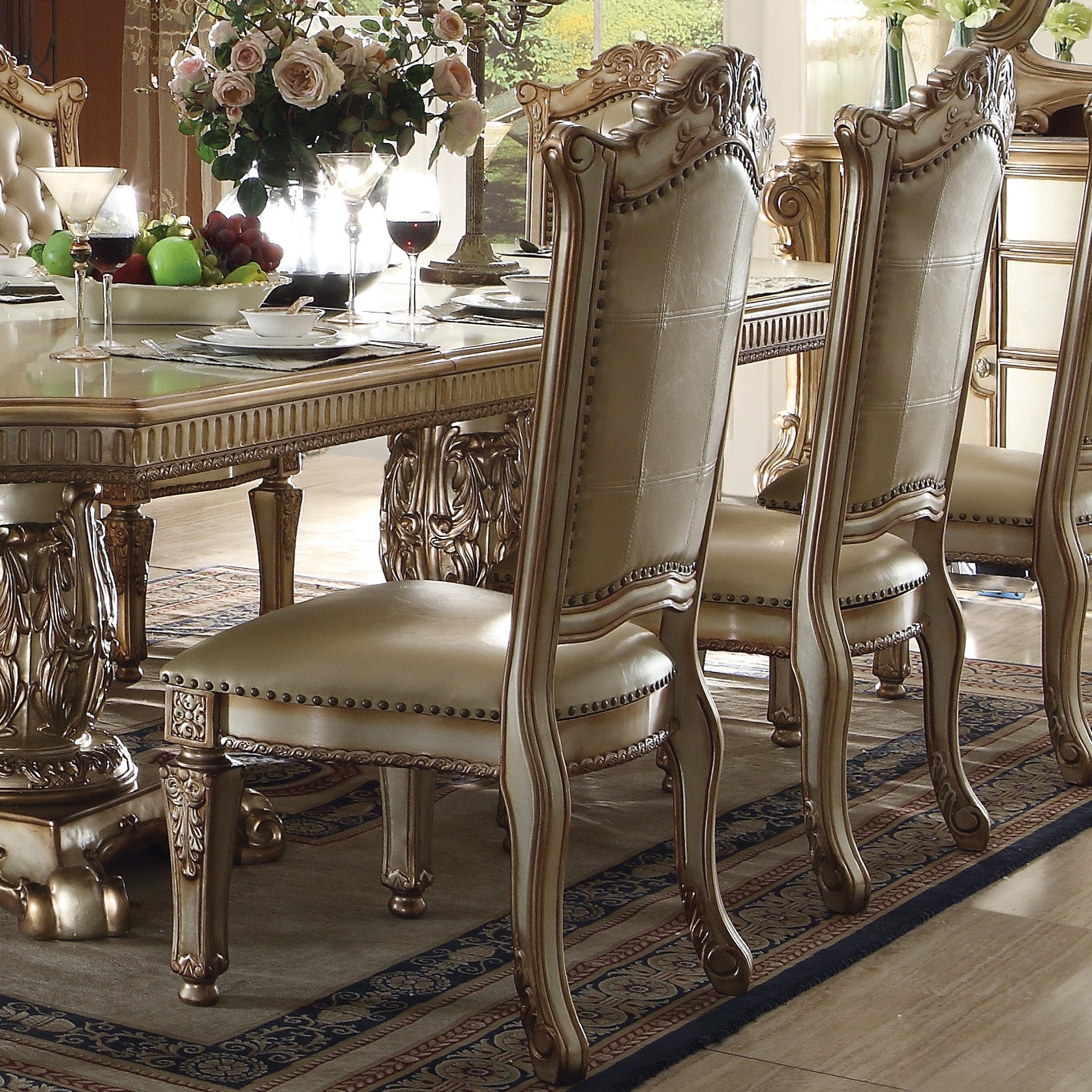 Antiquestyle dining chair with beige leather upholstery and gold trim detailing