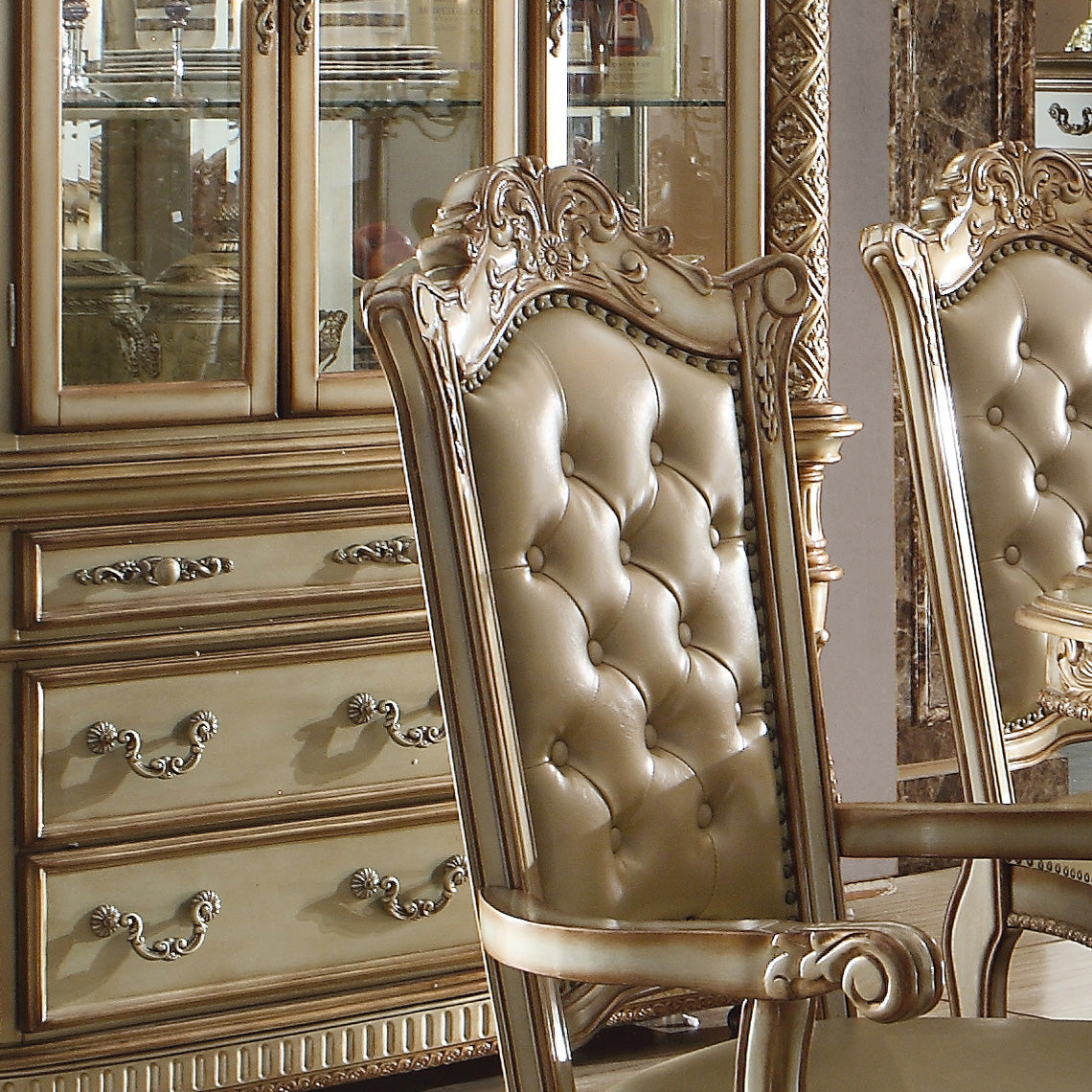 Tufted beige leather dining chair with ornate carved wooden frame and gold accents