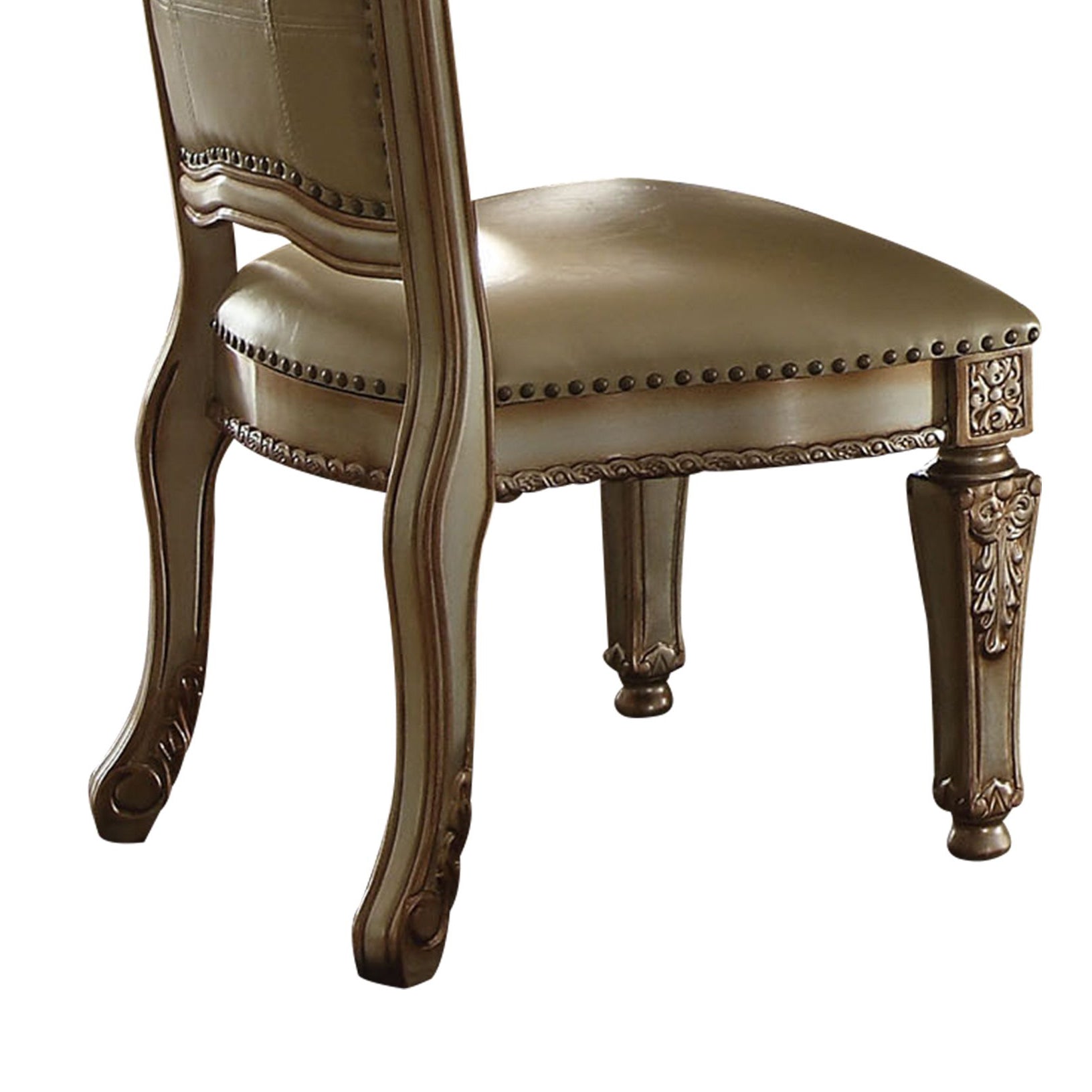 Ornate carved dark wood legs on a beige upholstered tufted dining chair