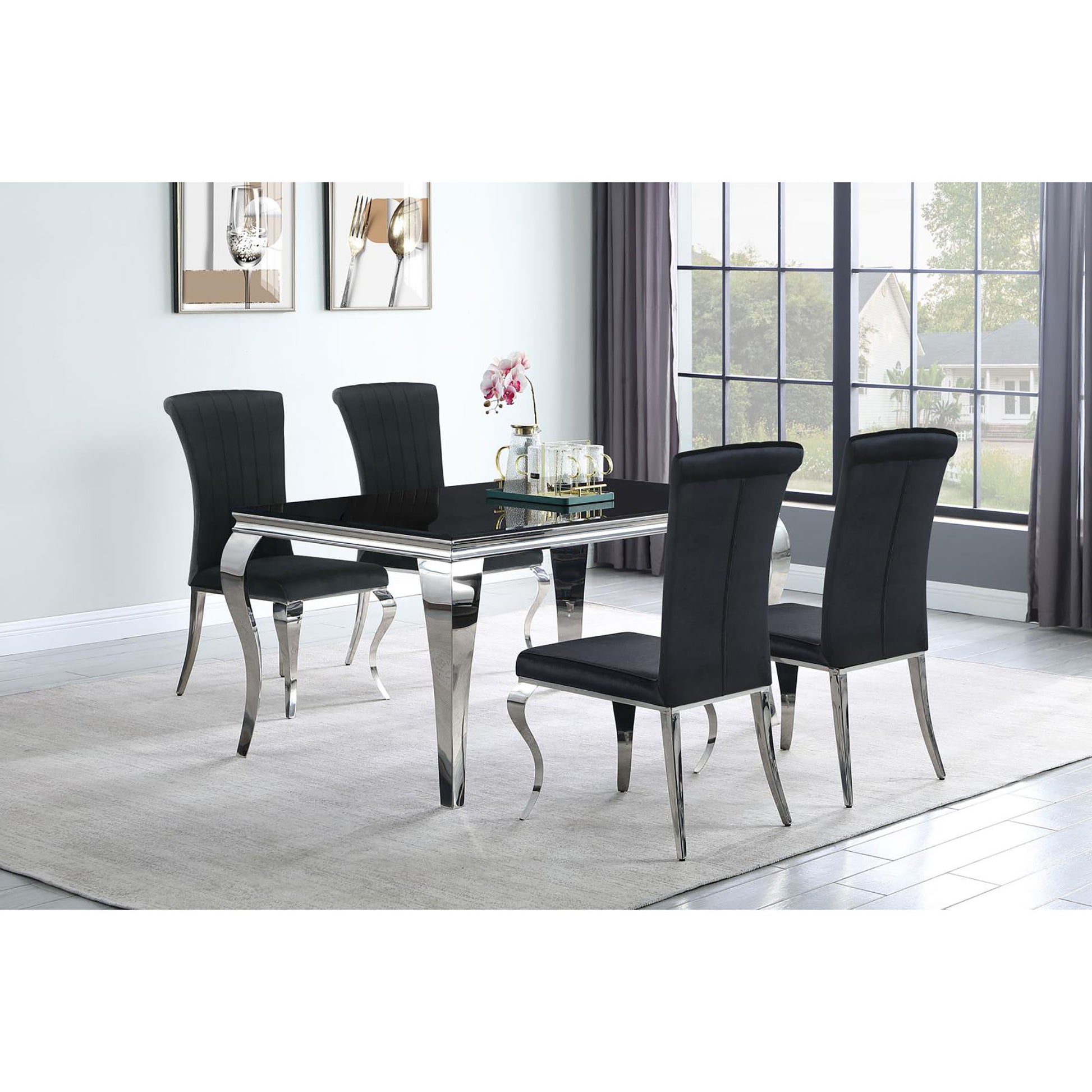 Black velvet dining chairs with chrome legs surrounding a sleek black glass dining table