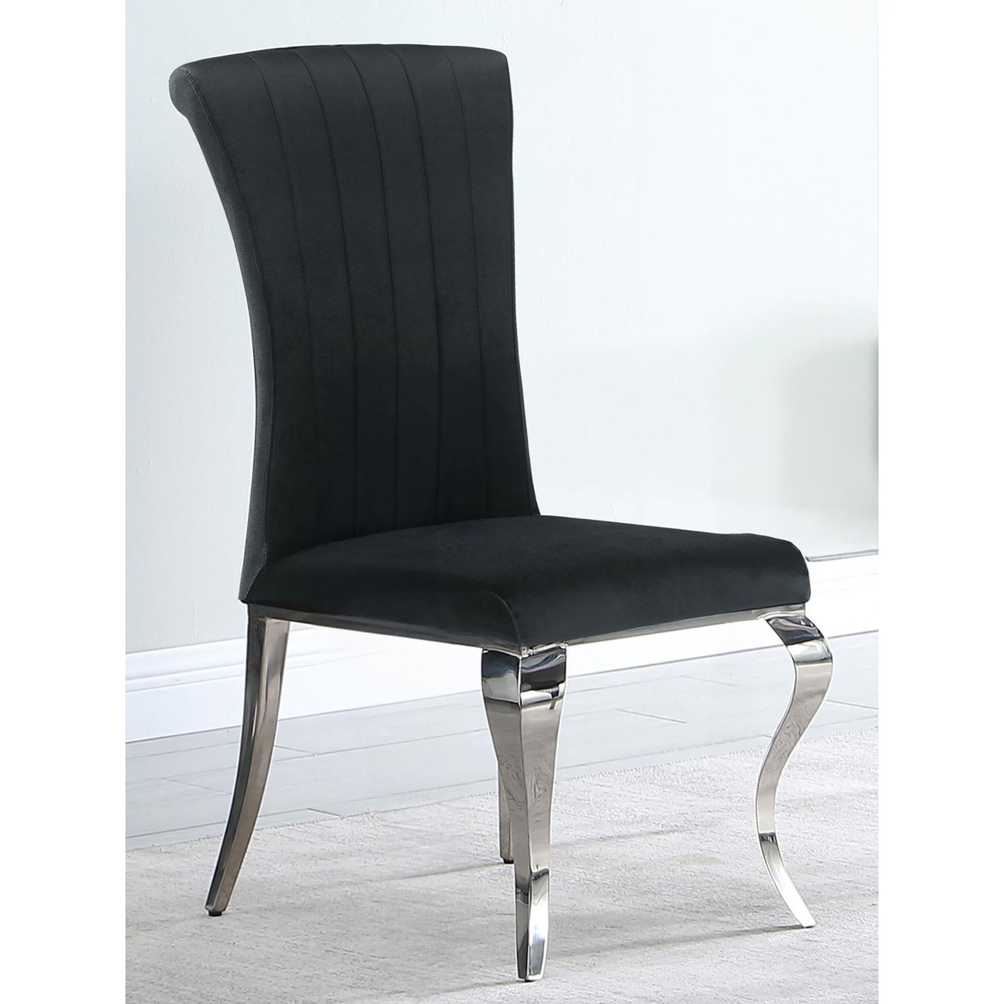 Elegant black velvet dining chair with chrome legs and vertical channel tufting for modern appeal