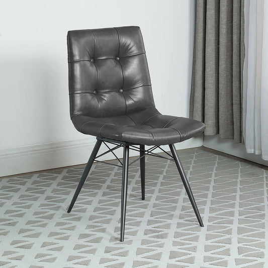 Dark grey faux leather dining chair with button tufting and metal legs