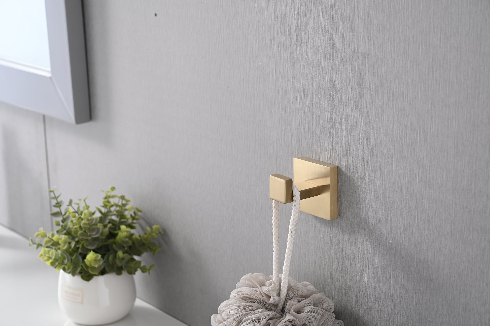 Brushed brass wall hook with a modern minimalist design ideal for bathroom accessories