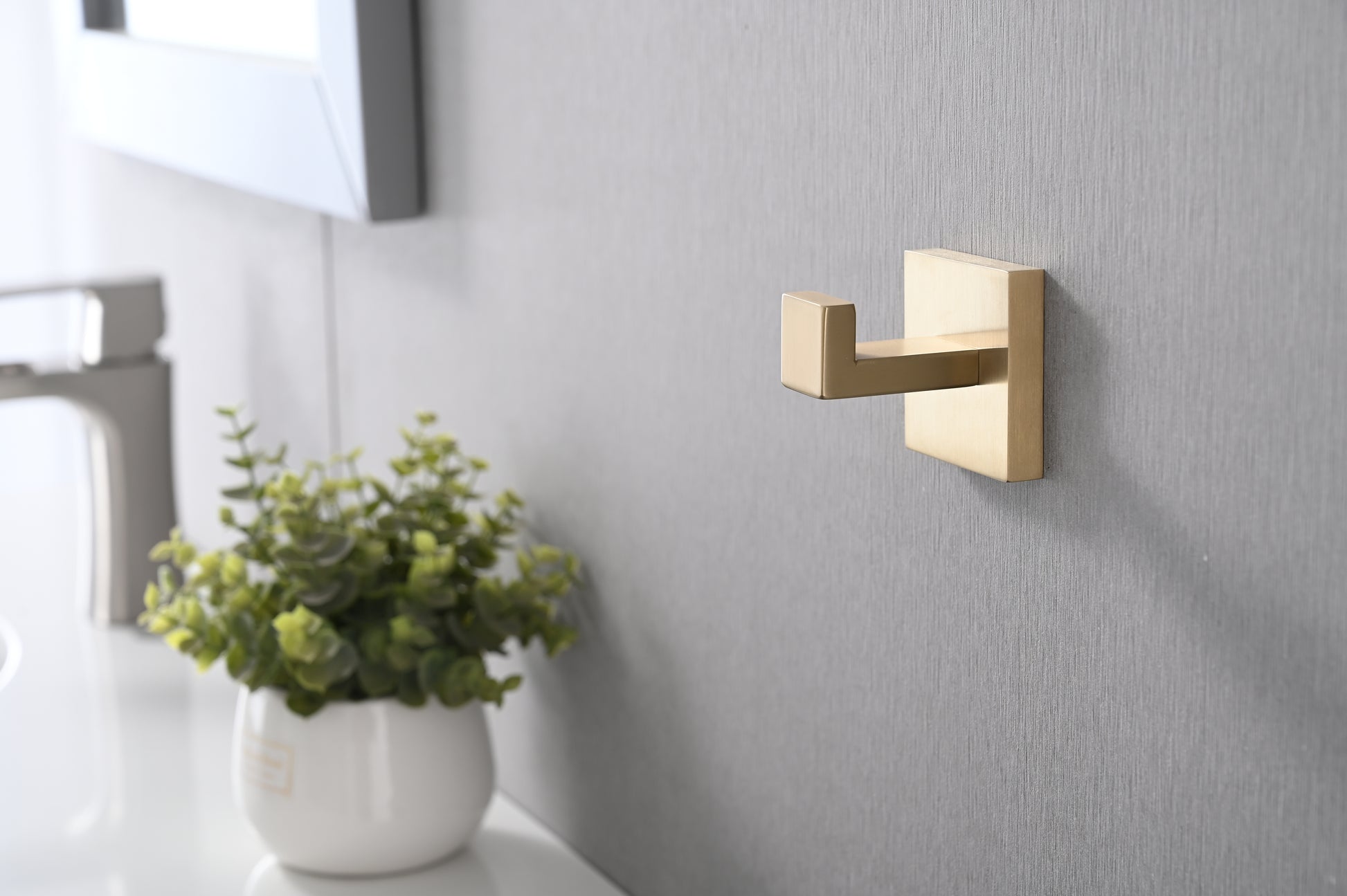 Brushed brass single wall hook with a modern minimalist design