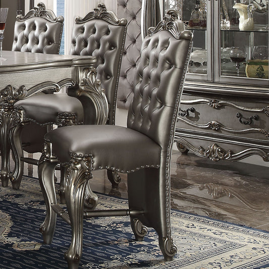 Tufted grey leather dining chair with ornate silver carved legs and nailhead trim