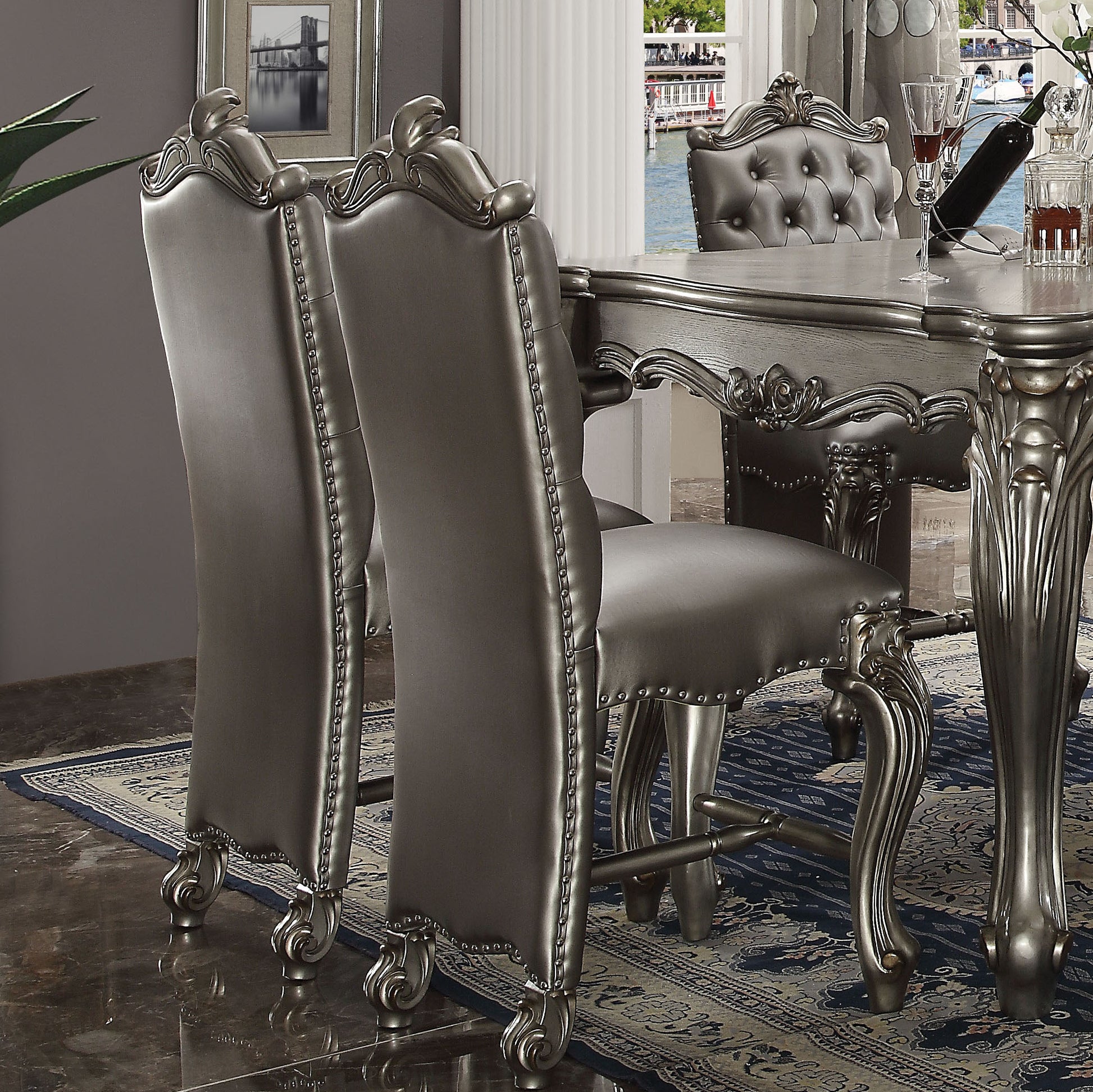 Silver faux leather dining chair with ornate carved legs and studded trim