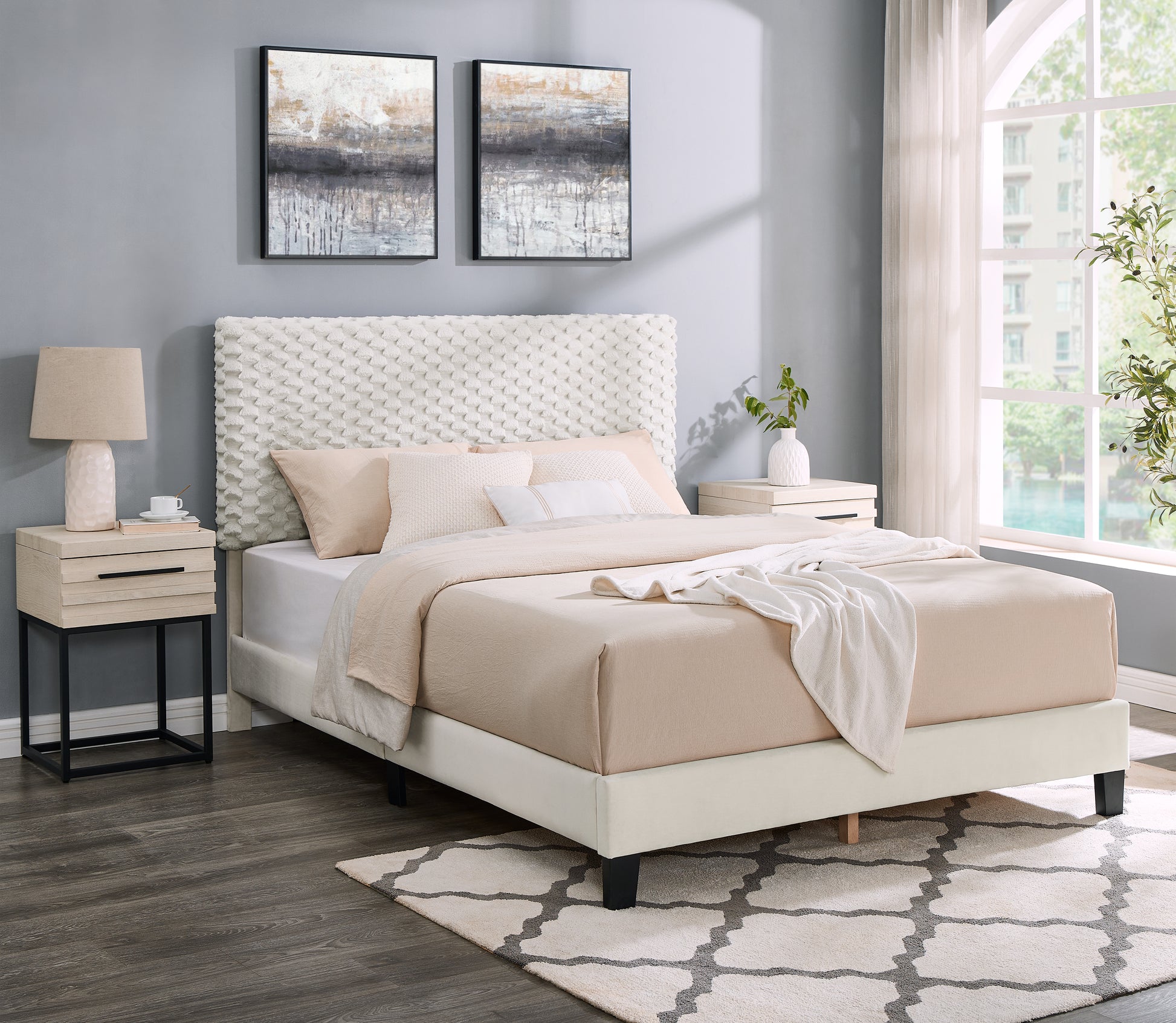 White upholstered king bed with textured headboard and beige linens
