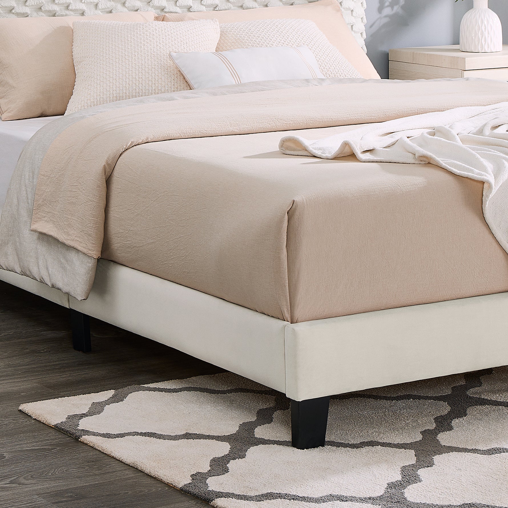 Cream upholstered bed frame with beige and white bedding